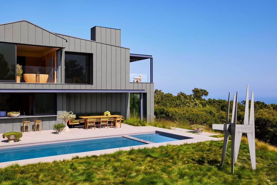ELLE DECORのインスタグラム：「On a ruggedly picturesque hilltop in Montecito, California, stands a home that’s a monument to self-sufficiency. But it wasn’t always that way. The devastating Thomas Fire tore through the house’s predecessor, a Spanish Mediterranean–style residence, in 2017, forcing the homeowners to embark on a new beginning. The couple had intended to rebuild their previous home as it was when designer and architect Jamie Bush (@jamiebushco) came on board, pushing them to consider a different direction entirely. Bush suggested a house constructed from hard-wearing materials, most notably fire-resistant standing seam metal cladding on the exterior. Landscape architect Franz Design Studio (@franzdesignstudio) then stepped in with local plantings like manzanita, native buckwheat, sage, and California lilac. Air circulates easily throughout the house, and with the windows open, more than just the California breeze comes in. “You hear croaking frogs and birds at all times of the day,” says Bush.   Click on the link in the bio for the full tour available exclusively on elledecor.com. Written by @cokhio. Styled by @tessawatson. Photographed by @yoshihiromakino.」