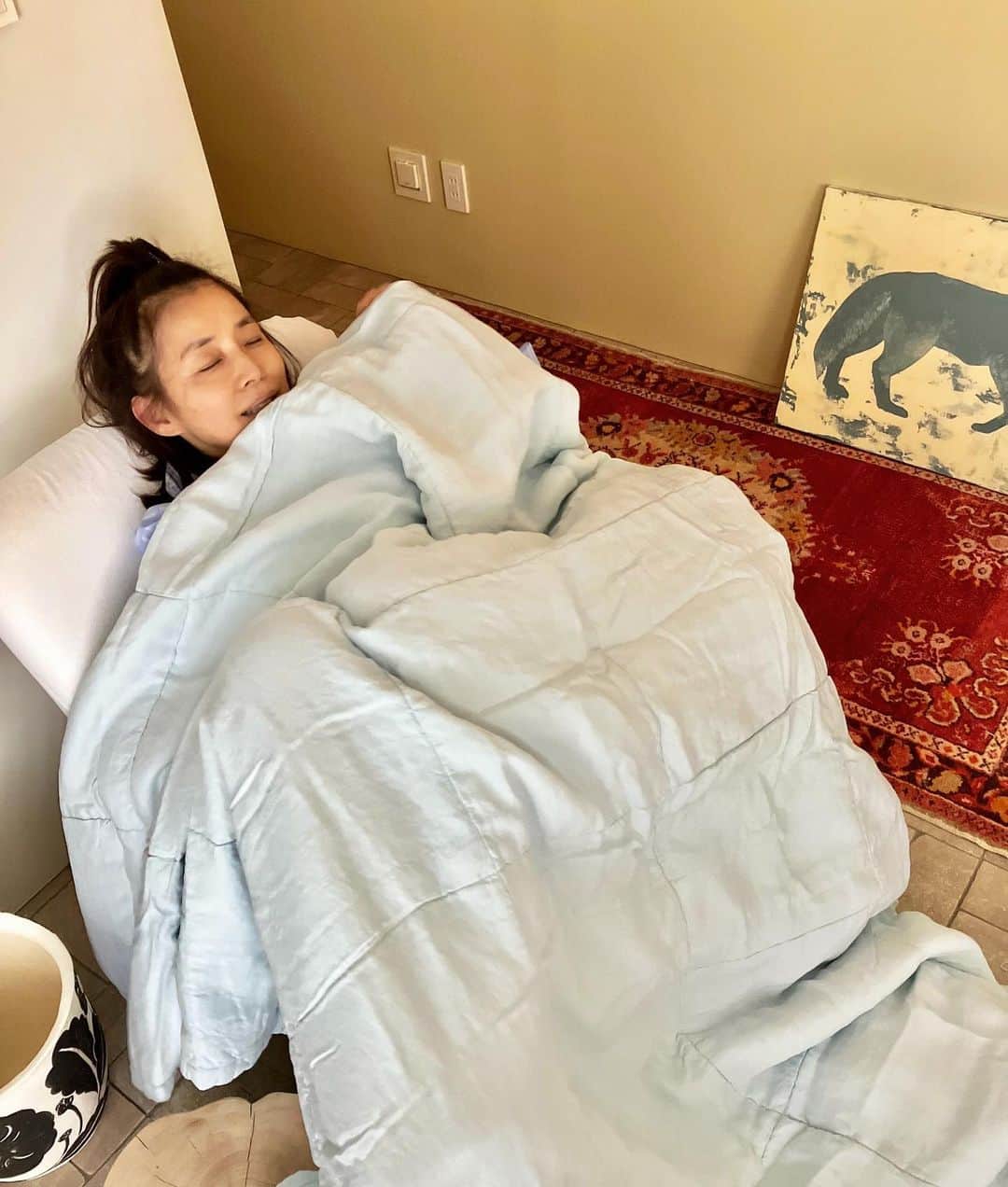 石田ゆり子のインスタグラム：「寒い朝。雨の東京。 写真は昨日のわたくし。 誕生日に🎂と、すてきな贈り物を🎁 いただきました。 ベビーブルーの中綿のおふとんと ストライプの大きなタオル(タオルケット？) パジャマ(上だけ着てる👀) 嬉しすぎます。ありがとう🎂🙏🏻 そして 家にいる時私はだいたいこの髪型をしてます…」