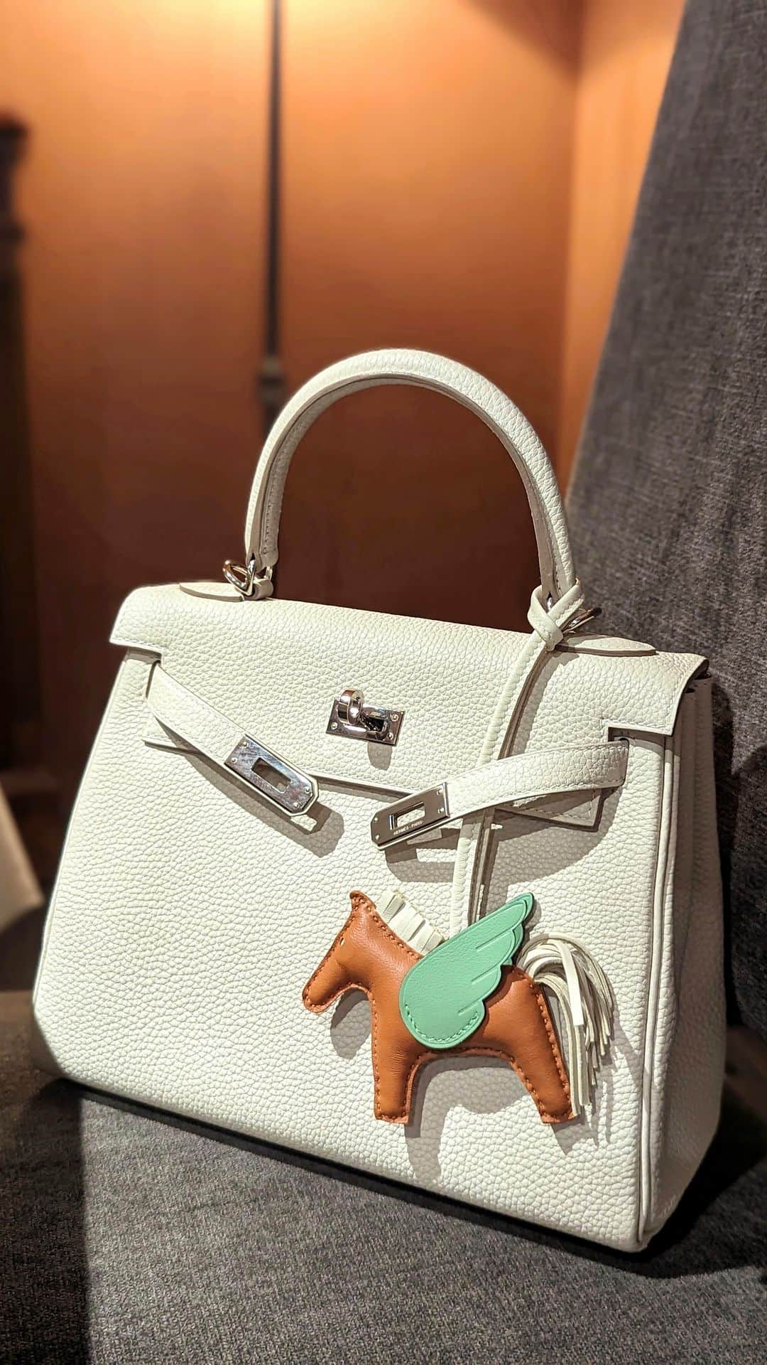 安岡あゆみのインスタグラム：「. @hermes エルメスロデオペガサスチャーム🦄 エルメス本店でバーキンを出していただいた時に、こちらも似合いそうだからどう？と🍊 ゴールド×クレ×ヴェールクリケット🤎🤍💚 今までバーキンやケリーは何も付けずにシンプルに持ちたい派だったのですが、ファッションによっては外しアイテムとして取り入れると可愛いことに気づきました💭 . . #hermes #hermesparis #hermescharm #hermespegasus #kelly #kelly25 #ayumi_y_ootd #エルメス #エルメス本店 #エルメスパリ #エルメスチャーム #エルメスペガサス #ケリー #ケリー25」