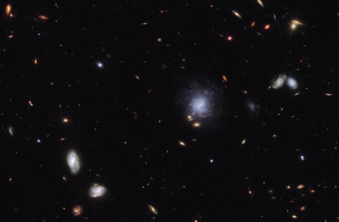 NASAのインスタグラム：「It takes two to tellurium!   @NASAWebb worked with ground-based telescopes and Fermi, Swift, and Chandra observatories to study the aftermath from the merger of two neutron stars. Webb helped identify the element tellurium produced from the event.  Image description: Bright galaxies and other light sources in various sizes and shapes are scattered across a black swath of space: small points, hazy elliptical-like smudges with halos, and spiral-shaped blobs. The objects vary in color: white, blue-white, yellow-white, and orange-red. Toward the center right is a blue-white spiral galaxy seen face-on that is larger than the other light sources in the image. Toward the upper left is a small red point.  #NASA #Webb #Space #JWST #NeutronStar #Universe」