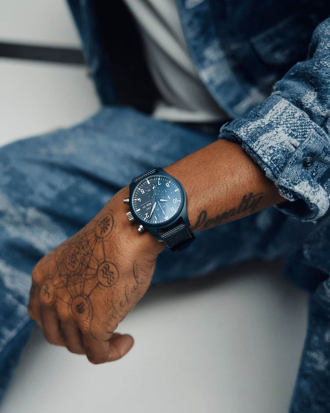 IWCのインスタグラム：「Born from a powerful creative gesture, our Pilot's Watch Chronograph 41 Top Gun Oceana sits on the wrist of @lewishamilton. This new Oceana-colored timepiece features a matching blue rubber strap with a denim finish textile inlay.  📸 Ref. IW389404  #IWCpilot | #TheReference | #IWCtopgun | #IWCoceana | #LewisHamilton」