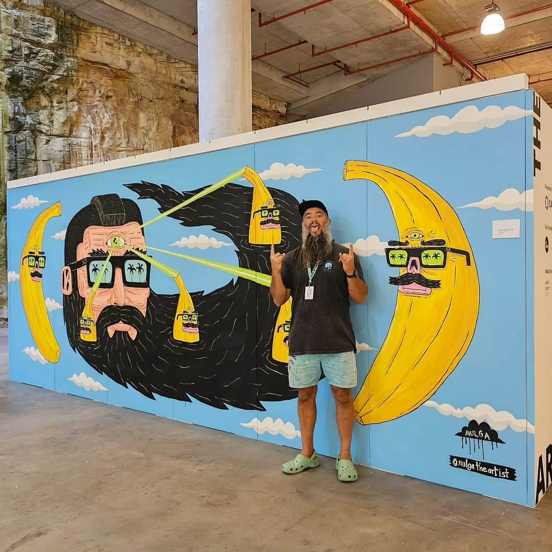 MULGAのインスタグラム：「Good times meeting peeps and painting a Laser Larry and his Banana Boys mural at⁣ @theotherartfair this weekend🍌😎🍌⁣ ⁣ Let me know if you're interested in purchasing the mural artwork. ⁣ ⁣ And the smaller version original artwork of Laser Larry is also currently available in my internet shop. Whoo! ⁣ ⁣ #mulgatheartist #theotherartfair #beardart #surfart #bananaart #muralart #artistlife #artistsofinstagram #art #artoftheday #arte #artcollector #australianart #australianartist #artistsoninstagram #ArtisticExpressions #artist」