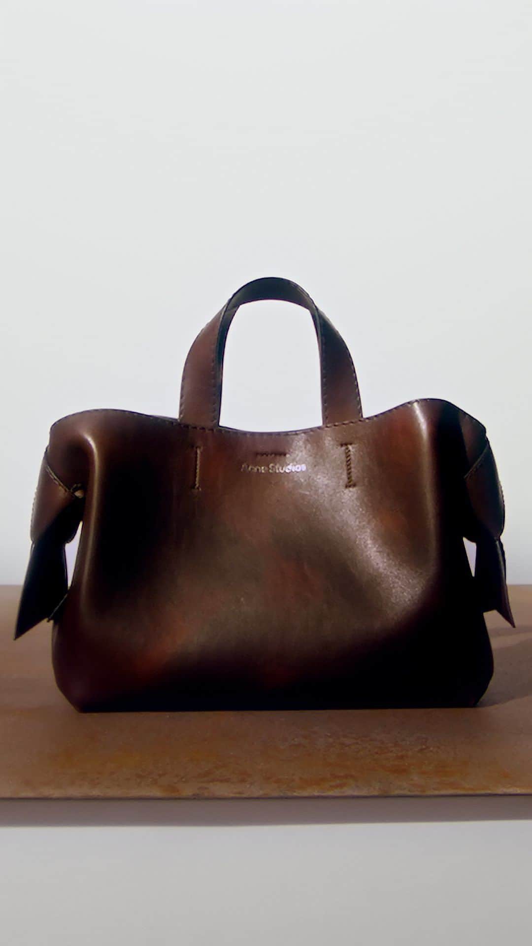 Acne Studiosのインスタグラム：「Our signature bag in vintage brown: the #Musubi in the versatile midi size. Discover new FW23 bags, online and in store now.   Director: #JeanMarieBinet (@JimBiners)⁣⁣ Set designer: #AliceKirkpatrick (@Alicekpk)」