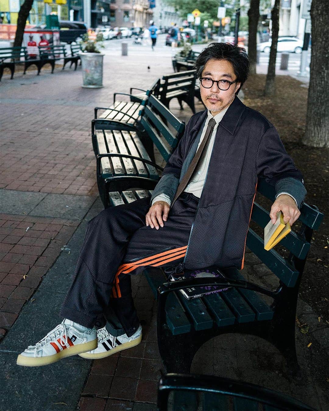 ケンゾーミナミのインスタグラム：「Repost from @songforthemute:  SONG FOR THE MUTE x ADIDAS 002 — Campaign by Atsushi Nishijima.  Jima (@jimagraphy) observes Kenzo on a park bench, an artist and friend. New York City, 2023. @kenzominami  “SFTM-002” releases globally on Friday, 20th of October @adidasoriginals  #SFTMxADIDAS #SFTMCOLLABORATIONS #songforthemute #kenzominami #jimagraphy」