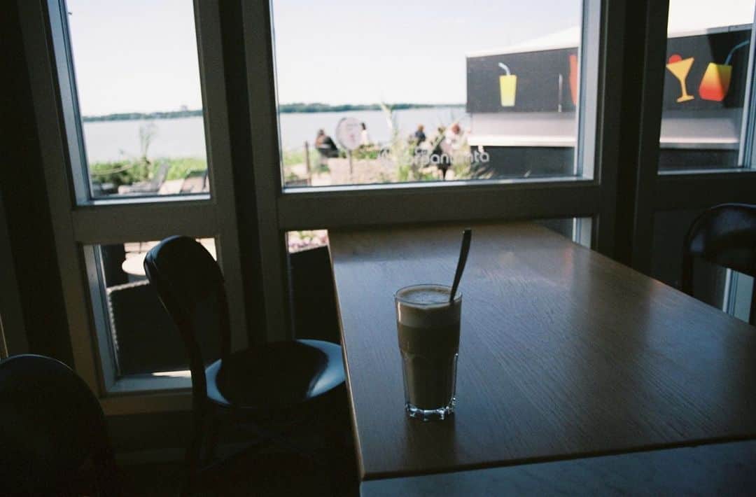 平岡佐智男さんのインスタグラム写真 - (平岡佐智男Instagram)「北欧新婚旅行15（北欧」カフェ巡り4）：フィンランドは歩いたら何かあるから大丈夫だ  アアルト邸の受付を済まして入るまでの1時間あった。 アアルト邸の周りは住宅街のため何もなさそうだし、28度ぐらいあってフィンランドにしてはもとても暑いし日だったので、その場で座ってるわけにもいかず、どうしたものかと思ったが、その辺を歩いてみるとなんとかなるものだ。  フィンランド式の狛犬がいるんだなと言ってみたり、日本の街ではあまりみないような植物もあるし、湖のカフェを見つけたりできる。 1時間なんてあっという間だ。  入ったカフェは「Café Toropicana」 アアルト邸の待ち時間はみんなここに来るのではないかと予想できた。 現地の人が多く、湖のほとりのカフェと言った雰囲気で、テラス席が好きなようだった。妻は日差しがキツすぎるのが苦手なので外が見える店内の席に座った。 コーヒーやラテなどのドリンクの他に、瓶や缶に入ったドリンクの量が凄まじかった。と思ったら、サンドイッチやケーキの種類もすごかったので、基本的にメニューが多い店だった。  僕はムーミンのクレジットカードを持って行っていたが、これがお会計の時にけっこうウケる。「おー。ムーミ！」と言ってほほ笑んでくれる。フィンランドの人は温かい。 ただ店員さんと会話する時は「アイラブムーミン」一択でいい。「ムーミンを探しにきた」「日本のムーミンと呼ばれている」などはきょとんとされるので気をつけた方がいい。  テラスに出てみると、思っていたよりも広いテラス席が広がっていて開放感に溢れていた。 その少し先に行くと湖の上に少し出張ったような席があり、特別感があった。 誰もいなかったので、ここで写真取ろうと思った。すごく綺麗だったので妻も呼ぼうかと思ったが、とても暑い日だったし、結構歩いていたので、疲れているだろうなと思い、呼ばずにタイマーで写真を撮った。 無理やり呼んでいたら怒られてただろうな〜と思い、戻ると、出発まで5分ぐらいしかないのに写真撮りに行って、ギリギリまで戻ってこないとはどういうことだと怒られた。  怒られる時は、怒られる。というか怒られる前から怒られることはもう起こっている。 全国の北欧新婚旅行をするご夫婦の夫の皆さんに伝えたいことは、出発前5分前までに着席しておき、妻の出発の号令を心穏やかに待った方がいいということだ。  #フィンランド #旅行 #旅行記 #新婚旅行 #カフェ巡り #北欧 #海外旅行 #ヘルシンキ #helsinki #finland #北欧カフェ」10月16日 19時15分 - sachio_coffeeforme