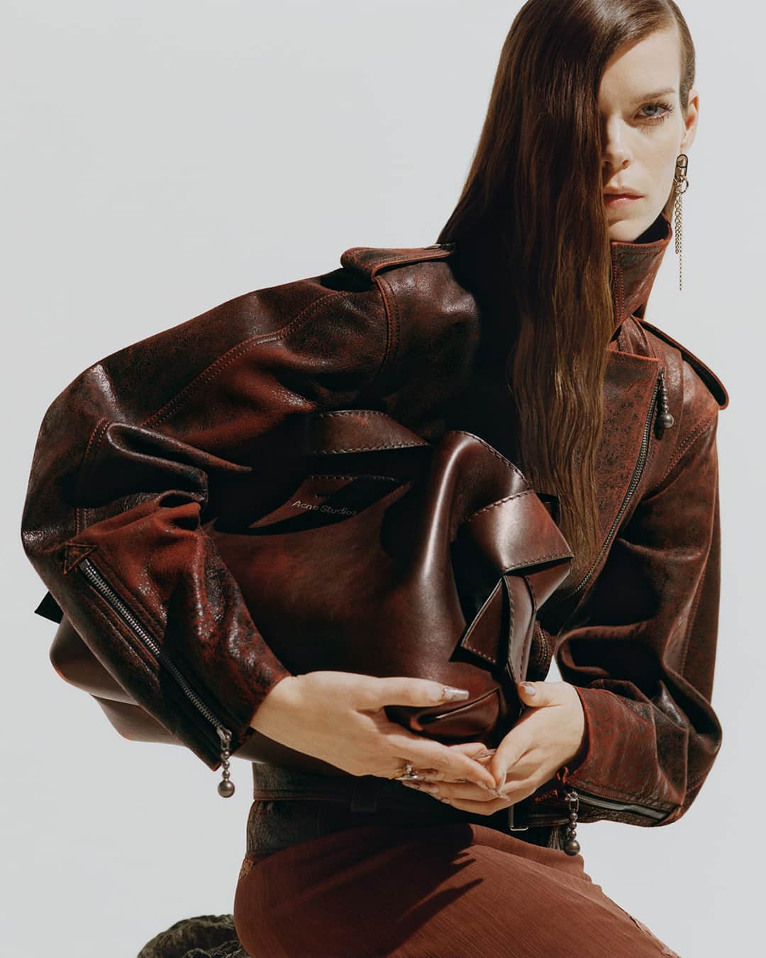 Acne Studiosのインスタグラム：「Leather on leather for a monochrome look. The #Musubi midi bag in vintage brown and our new hourglass biker jacket, now in store and online.⁣ ⁣ Photographer: @EstelleHanania⁣ Stylist: @Leopolda.Duchemin⁣ Hair: @TomWrightHair⁣ Make-Up: @Masae__Ito⁣ Set Design: #AliceKirkpatrick (@Alicekpk) ⁣ Casting: @JuliaLangeCasting⁣ Nails: @ElsaDurrens」