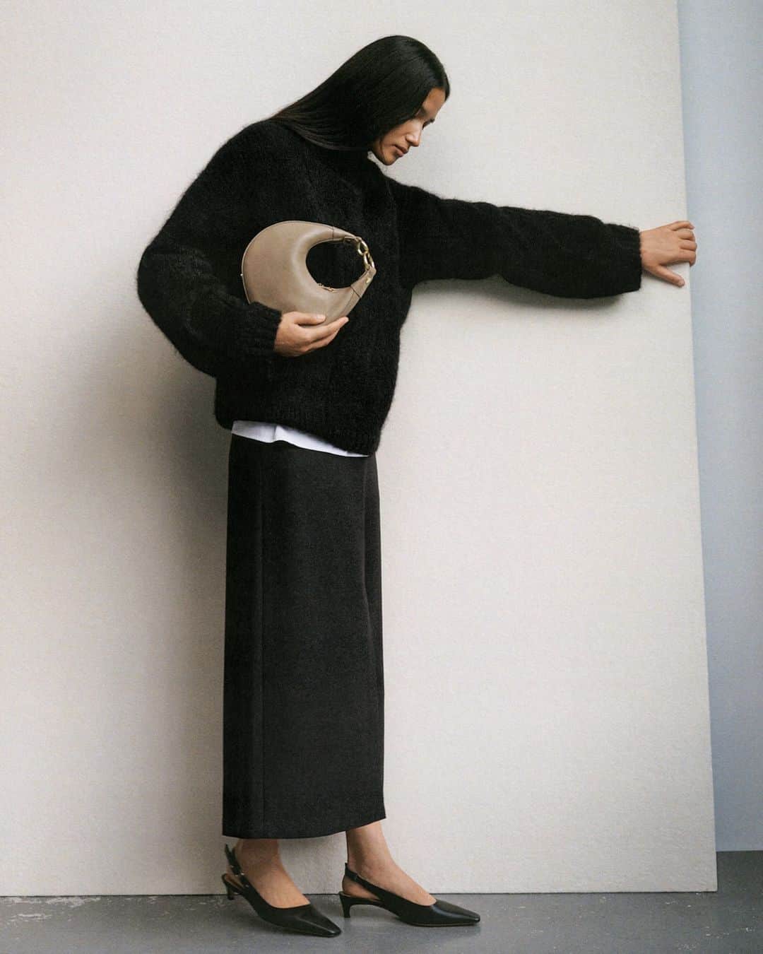 ARKETのインスタグラム：「This high-neck cable knit jumper is made from a blend of alpaca and responsible wool (C815571RAF). This fuzzy style has a comfort-inducing, oversized silhouette. Styled here with  our Long Wool-Blend Skirt and Half-Moon Leather Bag. Explore the full edit: link in bio. - #ARKET」