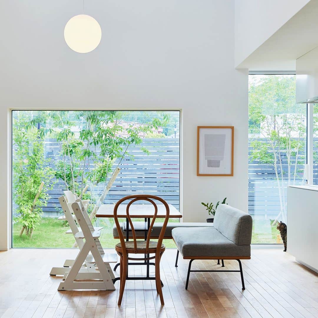 無印良品の家さんのインスタグラム写真 - (無印良品の家Instagram)「【住まいの実例】 ※右上のブックマークのアイコンをタップすると保存できます。  滋賀県湖南市 竣工年月：2020年6月 延床面積：125.8m²  滋賀県湖南市にある「窓の家」K邸は、モノトーンのシンプルな色合いが、緑の多い周りの環境にひときわ映えるお宅です。Kさんご家族は、ご夫妻と2人のお子さまに猫が2匹。「窓の家」に住んで、3年が経ちました。  「この家を例えると『白いお皿』かな、と思うんです。それもよくできたお皿。機能美があるし、丈夫で使いやすい。そして何より、盛り付けた時に料理が映えるんですよ」  今回は、「窓の家」のことをそう評する奥さまに、この家に住むまでと、住んでからのお話をお伺いしました。  家づくりは「すっきりとしたレイアウトで、ストレスなく生活できる、可変性の高い間取り」という基本のコンセプトをベースに、ご夫妻の希望を組み込んでいく形で進めていきました。  「ウォークインクローゼットなど収納スペースを確保した上で、生活空間には棚などをあまり置かないような間取りにすることを心がけました。1階は、階段の周りを回遊できるようにして、『行き止まり』のない間取りにして、生活動線をスムーズにしつつ、子どもたちが気持ちよく動き回れるような空間にしました。  LDKの空間を大きく取りたい、という意図もあって、浴室と洗面所は2階に設けました。2階は、将来子どもたちの個室が必要になることを想定して、可変性の高い間取りにもしてあります」  そのほかにも、冷蔵庫が収納できるスペースをつくったり、洗濯スペースとウォークインクローゼットを隣り合わせにしたりと、担当者とも細かくやりとりを重ねて完成させた住まい。実際の暮らし心地には、ご主人やお子さまたちも含めて、満足されているそうです。  2023.10.17公開住まいの実例『盛り付けた料理がひときわ映える「白いお皿」のような住まいです』より  詳しくはプロフィールハイライトか、「無印良品の家」HPをご覧ください。  @mujihouse  #無印良品の家 #mujihouse #窓の家 #無印良品の家_窓の家 #施工例 #施工事例集 #おうちづくり #マイホームメモ #キッチン収納 #キッチンインテリア #リビングインテリア #リビング収納 #本棚 #bookshelf #すっきりした暮らし #ねこと暮らす家」10月17日 17時00分 - mujihouse