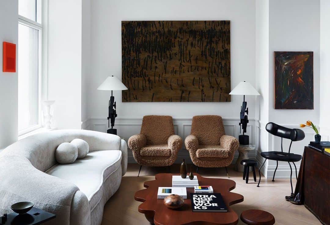 ELLE DECORのインスタグラム：「Design may be subjective but we’d bet one of Christian Siriano’s (@csiriano) designer handbags that this Manhattan living room is high-contrast perfection. Siriano shows up regularly to his TriBeCa neighbor’s door, bearing a vase or some other interesting piece from his own place that he thinks might actually work better in hers. He should know, after all—he designed the apartment. The fashion designer’s move into interior design was rather organic, growing out of his interest in custom fabrics, which he was making since his brand’s earliest days. “That’s how I fell in love with design,” he tells us. “As I began collecting art and getting older, I started to think of furniture and objects as investment pieces.”   Click the link in the bio to tour the rest of this airy apartment, as featured in our November 2023 issue. Written by @julie_coe. Photographed by @timlenzphoto.」