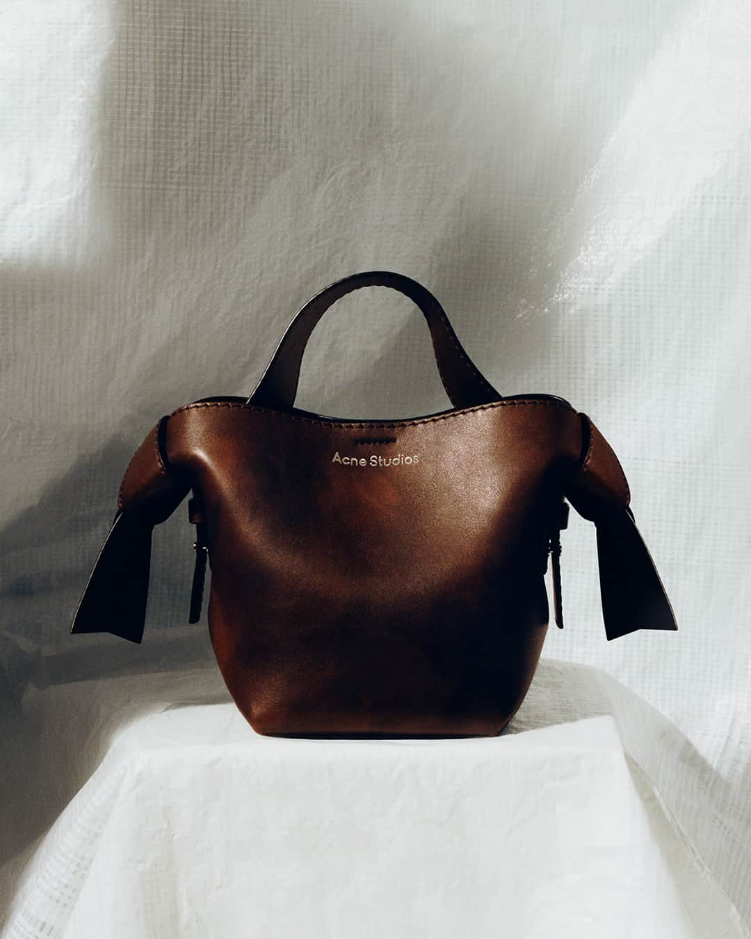 Acne Studiosのインスタグラム：「Vintage feel, textured brown. Discover the new declination of the #Musubi and #Distortion bags, #AcneStudios classics. Available now in store and at acnestudios.com⁣ ⁣ Photographer: #JeanMarieBinet (@JimBiners)⁣⁣⁣ Set designer: #AliceKirkpatrick (@Alicekpk)」