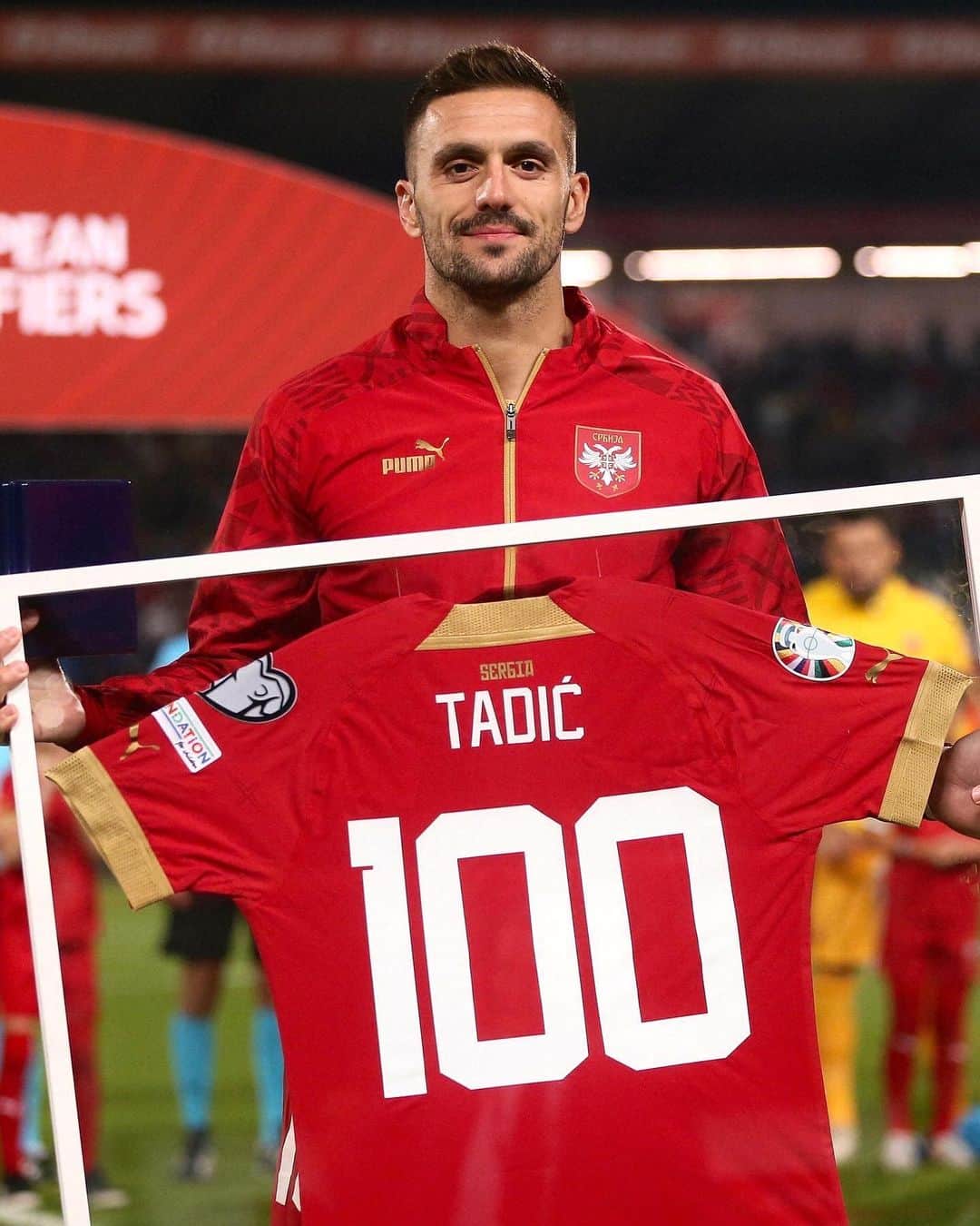 ドゥシャン・タディッチのインスタグラム：「💯🇷🇸 Капитен репрезентације Србије Душан Тадић је на утакмици против Литваније у Каунасу јубиларни 𝟭𝟬𝟬. пут бранио је боје нашег државног тима.  Тим поводом, специјалну плакету и урамљен дрес Душану Тадићу уручили су селектор „А” тима Драган Стојковић и потпредседник Фудбалског савеза Србије Бранислав Недимовић.」