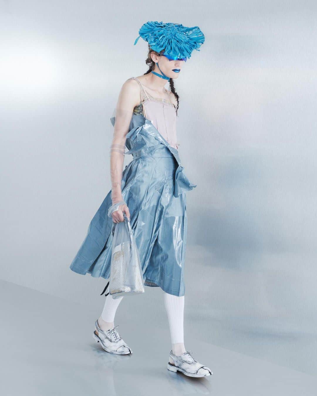 Maison Margielaさんのインスタグラム写真 - (Maison MargielaInstagram)「For the Spring-Summer 2024 Co-Ed Collection, Maison Margiela stages a search for individual truth reflected in the generational adaptation of an inherited wardrobe. Evoking the memory of one age through the radical eyes of the next, Creative Director John Galliano triggers a chemical reaction between eras and attitudes founded in a flashback narrative imagined within the Maison’s ongoing chronicle of the characters Count and Hen.  Look 26. Lilac silk-mikado exfoliage skirt worn over a slate decortiqué bustier applied with pressage. Rose pink binliner headpiece woven in the memory of a mid-century hat, Maison Margiela x Gentle Monster black chrome robotic mask sunglasses, violet tulle illusion opera gloves, white silk-cotton knee-high ribbon socks, bianchetto leather Tabi bourgeoise spectator pumps, and a bianchetto basket-weave fortune cookie bag encased in a violet tulle illusion carrier bag. Model @anyyier   Look 27. A dove grey exfoliage skirt applied with pressage worn over an Eau de Nile silk-taffeta decortiqué romper. Mint binliner headpiece woven in the memory of a mid-century hat, Maison Margiela x Gentle Monster chrome robotic mask sunglasses, sage tulle illusion opera gloves, white silk-cotton knee-high ribbon socks, bianchetto leather Tabi bourgeoise spectator pumps, and a bianchetto basket-weave cylinder bag encased in a sage tulle illusion carrier bag. Model @vilmasj   Look 28. Slate grey exfoliage skirt applied with pressage worn over a Recicla rose taffeta romper. Petrol blue binliner headpiece woven in the memory of a mid-century hat, Maison Margiela x Gentle Monster blue chrome robotic mask sunglasses, slate tulle illusion opera gloves, white silk-cotton knee-high ribbon socks, bianchetto leather Tabi monster sling-backs, and a bianchetto basket-weave cylinder bag encased in a slate tulle illusion carrier bag. Model @tijs_van_der_gun」10月19日 0時02分 - maisonmargiela