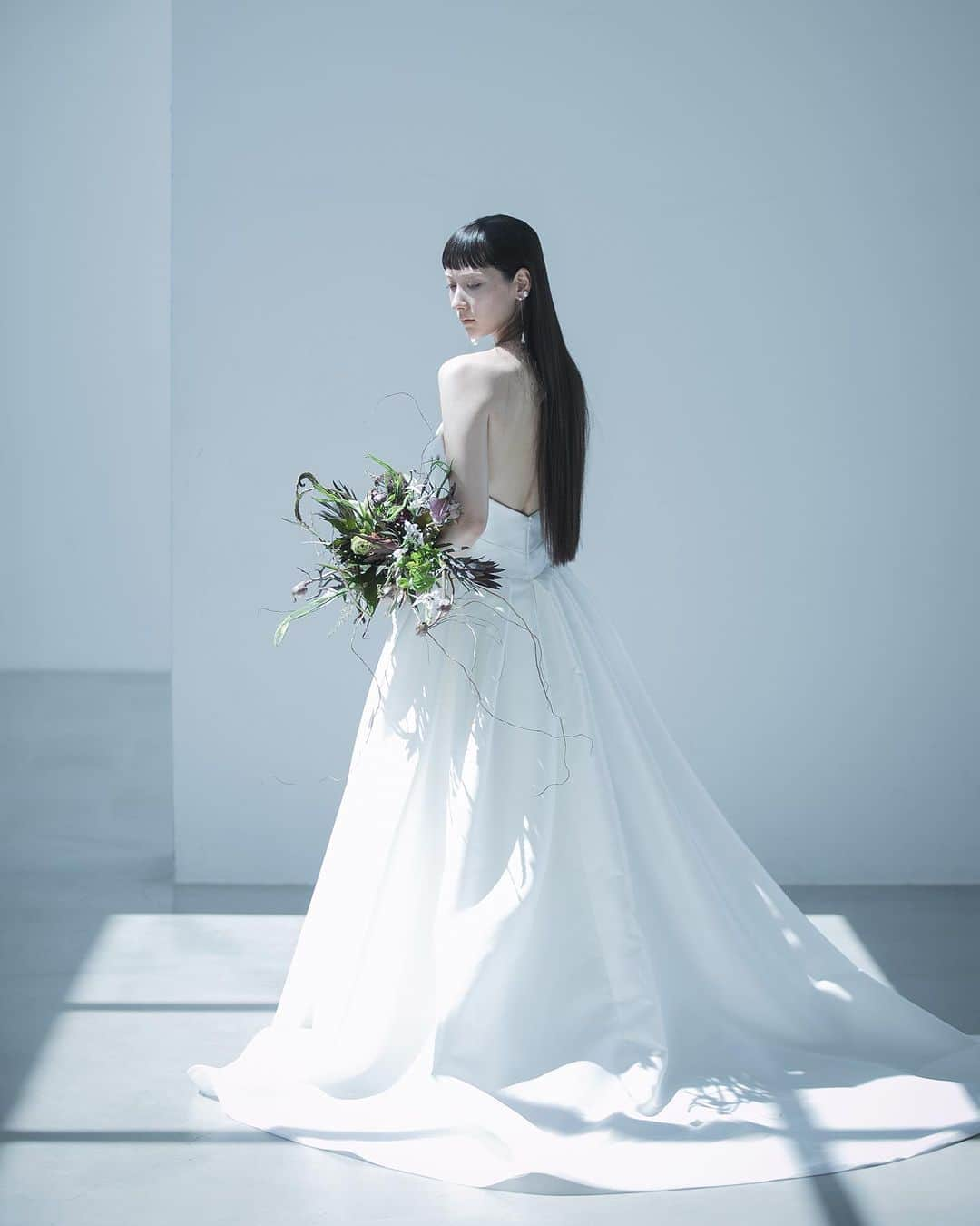 nae.ATELIERのインスタグラム：「nae.ATELIER 2023 new dress 【”edona”(エドナ)】  明るく、思い切りよく人生を生きる女性をイメージしてお作りしたドレス。  胸元に多数入る直線的なカットが 視覚的に凹凸があるように見せ、 ウエストからふわりと広がるスカートが ウエストを細く、 全体のバランスにメリハリをつける 溌剌とした存在感を放つAラインドレスです。  “Edona” is A-line dress made of Mikado-silk, for the brides who live brightly and positively.  The many straight cuts on the chest parts and the skirt that gently spreads out from the waist make sharpness to the overall balance of the body.  nae.ATELIER 東京都渋谷区恵比寿南1-13-2 EBISU COURT 101 TEL:03-6409-6369  #大好きと大切をすべてまとって #naeatelier #アトリエナエ #nae花嫁 #bridestyle #overseaswedding  #destinationwedding #elopementwedding #naebride #ウェディングドレス #シンプルドレス #Aラインドレス」