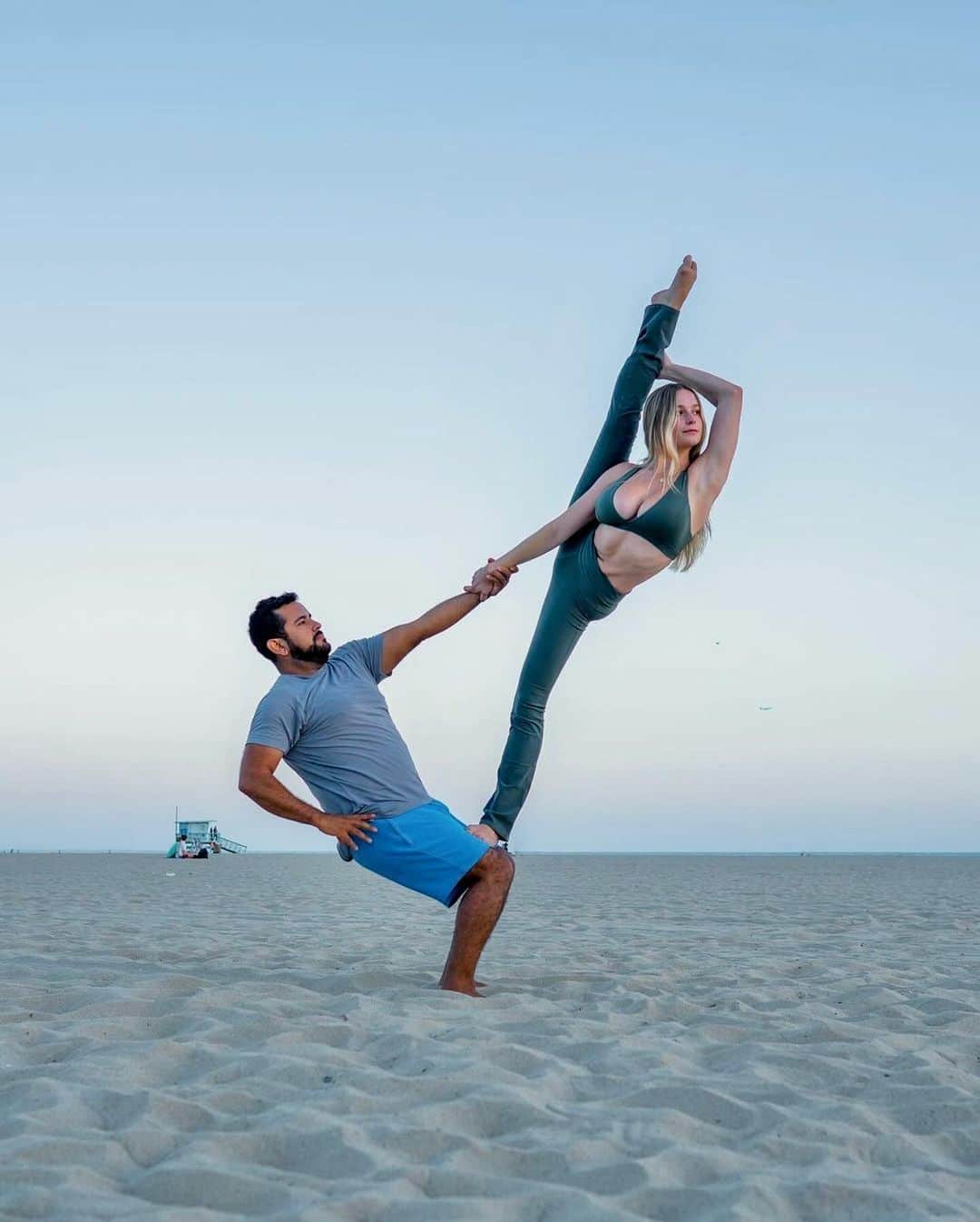 ALO Yogaのインスタグラム：「Making epic shapes with your friends ⚡️ @acrowithjon + @georgia.bryan balance at the beach 🌊」