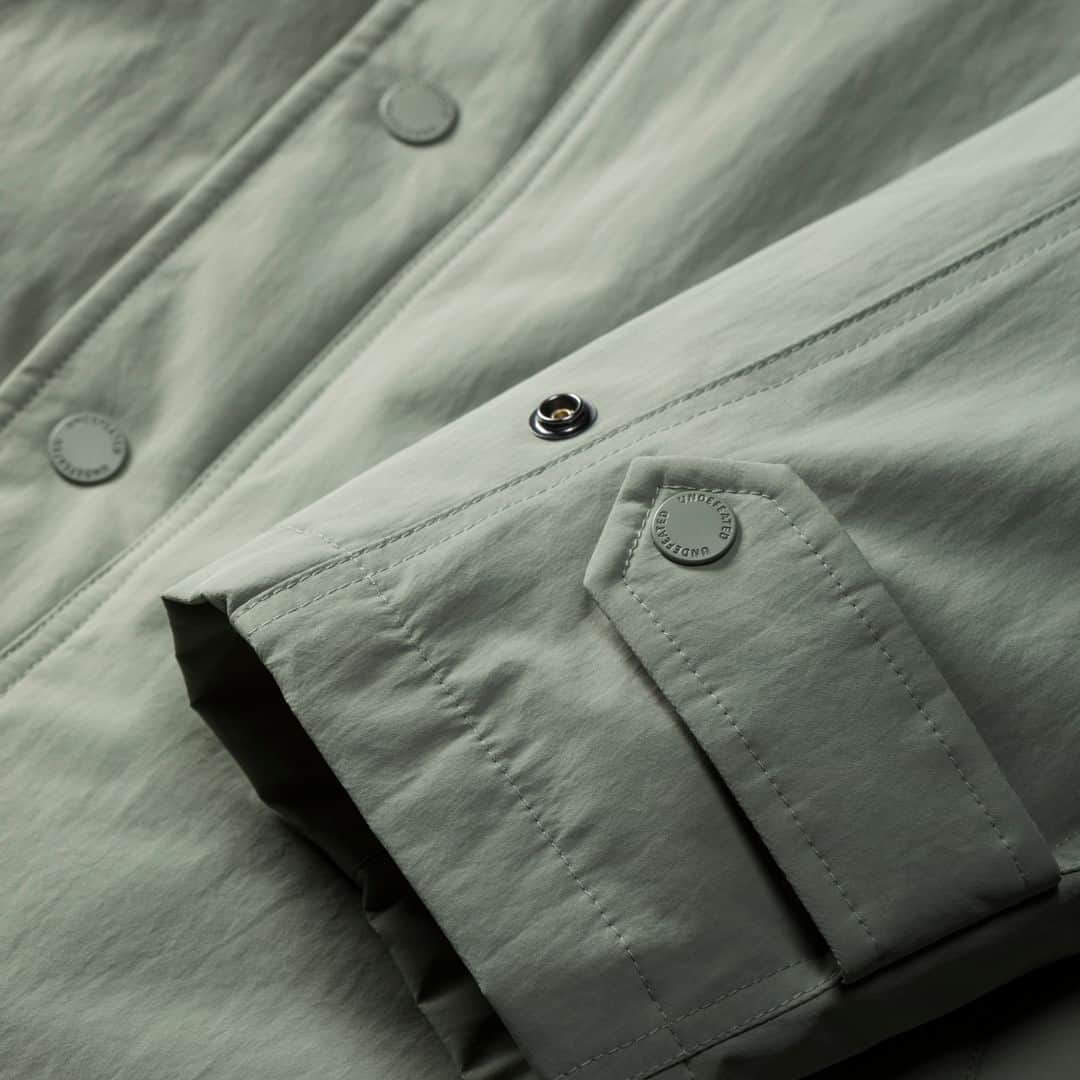 UNDFTDさんのインスタグラム写真 - (UNDFTDInstagram)「A detailed look into UNDEFEATED FALL 23 - Drop 6  The UNDEFEATED Tech Trench is a 100% nylon piece featuring a down-filled ripstop lining, an interior zip placket and chest pocket, adjustable hood and cuffs and a soft hand screen printed UNDEFEATED wordmark on the left side of the chest. Available in Light Sage and Black.  Available Friday, 10/20 exclusively at all UNDEFEATED Chapter Stores and Undefeated.com」10月20日 5時00分 - undefeatedinc