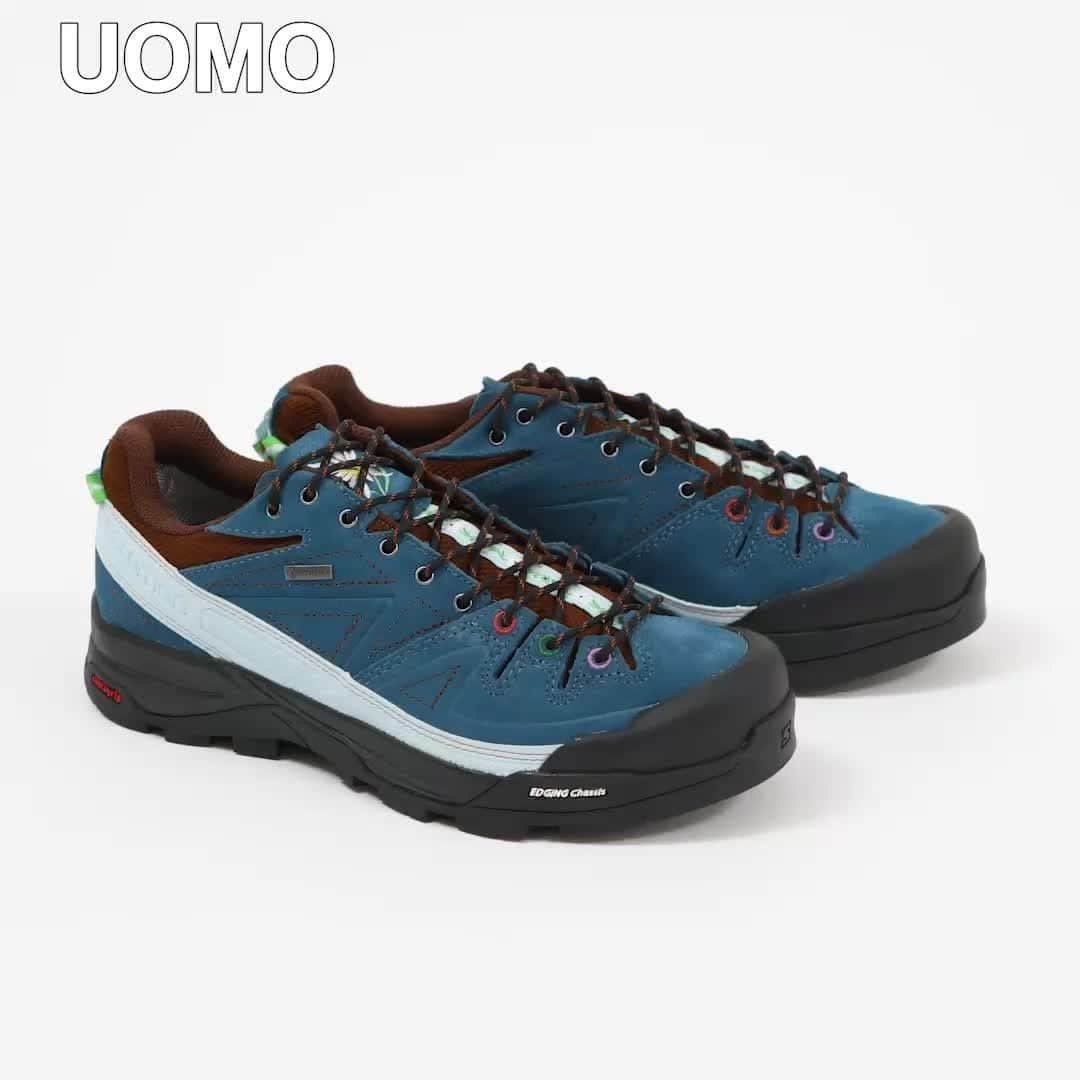のインスタグラム：「エディター私物 SALOMON×The Broken ArmのX-DESALPES  靴は黒ばかりという、ここ数年のマンネリ化した足元を変えてくれたのが、このトレッキングスニーカー。フランスの人気セレクトショップ、ザ・ブロークン・アームとサロモンのコラボモデルで、深いターコイズブルーの色味にやられた。  ソリッドさが控えめで、シューホールがカラフルだったり、シュータンには花の刺繍がされていたりと、普段なら絶対に選ばないデザインなのだが、むしろその抜けた感じに惹かれてしまった。「サロモンなのに、なんかかわいい!?」という、オリジナルとはちょっと違うアプローチで作られているのがいい。  ゴアテックス®仕様なのだし、キャンペーンビジュアルのように雨水や泥を気にせずタフに楽しむのが正解なのだろうが、しばらくはきれいなターコイズブルーを汚さないよう丁寧に履く予定。  UOMO編集 中林  #エディター私物 #SALOMON　#スニーカー #uomo #uomo_magazine #webuomo」