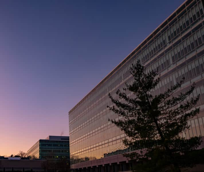 CIAのインスタグラム：「Pictured here, shortly before sunrise, is what #CIA calls its "New Headquarters Building" or NHB.  As you may remember from a previous #PhotoOps post, the "Original Headquarters Building" (OHB) was designed in the mid-1950s and completed in 1961. By the early 1980s, the Agency needed more space.  The final approved design was what is now known as NHB: two, six-story office towers built into a hillside behind OHB. Linked to the OHB in a seamless blend of the two structures, the main entrance to NHB features a huge skylight ceiling and a spectacular view of OHB.  The groundbreaking ceremony for NHB took place on May 24, 1984; the building was completed by March 1991.  #LookAtLangley」