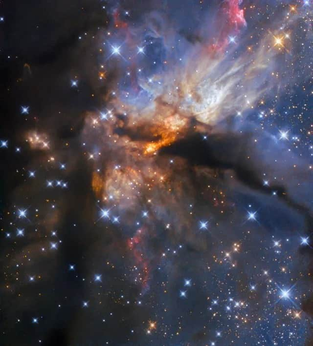 NASAのインスタグラム：「This image is probably what inspires the look for galaxy ice cream 🍨 ! @nasahubble captured this image showing a protostellar jet, which is an enormous, collimated beam of matter ejected from very young stars called protostars.   Image description: A nebula with stars. Dense clouds of dust and gas cover the left-hand side and a filament crosses the center horizontally. Billowing streams of gas and dust in various colors emerge from around the center. The very center of the image is permeated with glowing orange regions. Many blue stars with cross-shaped spikes lie in the foreground, and small point-like stars are visible beyond the clouds.」