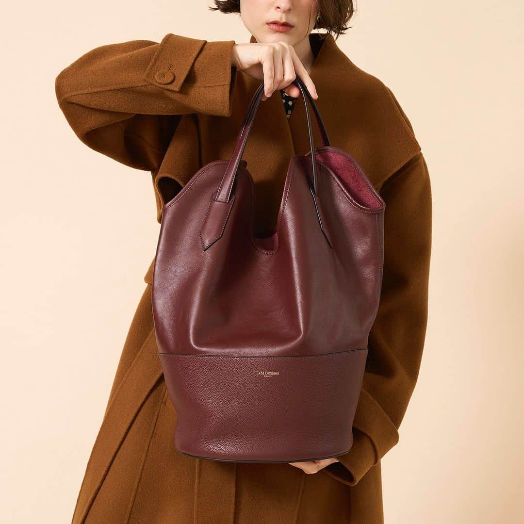 のインスタグラム：「大人気”RAY BUCKET/レイ バケット”から新色ワインが登場。 波打つような特徴的なシェイプが体にフィットし、コートの上からでも肩にかけてお持ちいただけます。 荷物がたっぷり入るので、ワーキングシーンやオフの日のカジュアルスタイルとも相性抜群です。  #jandmdavidson #ジェイアンドエムデヴィッドソン」