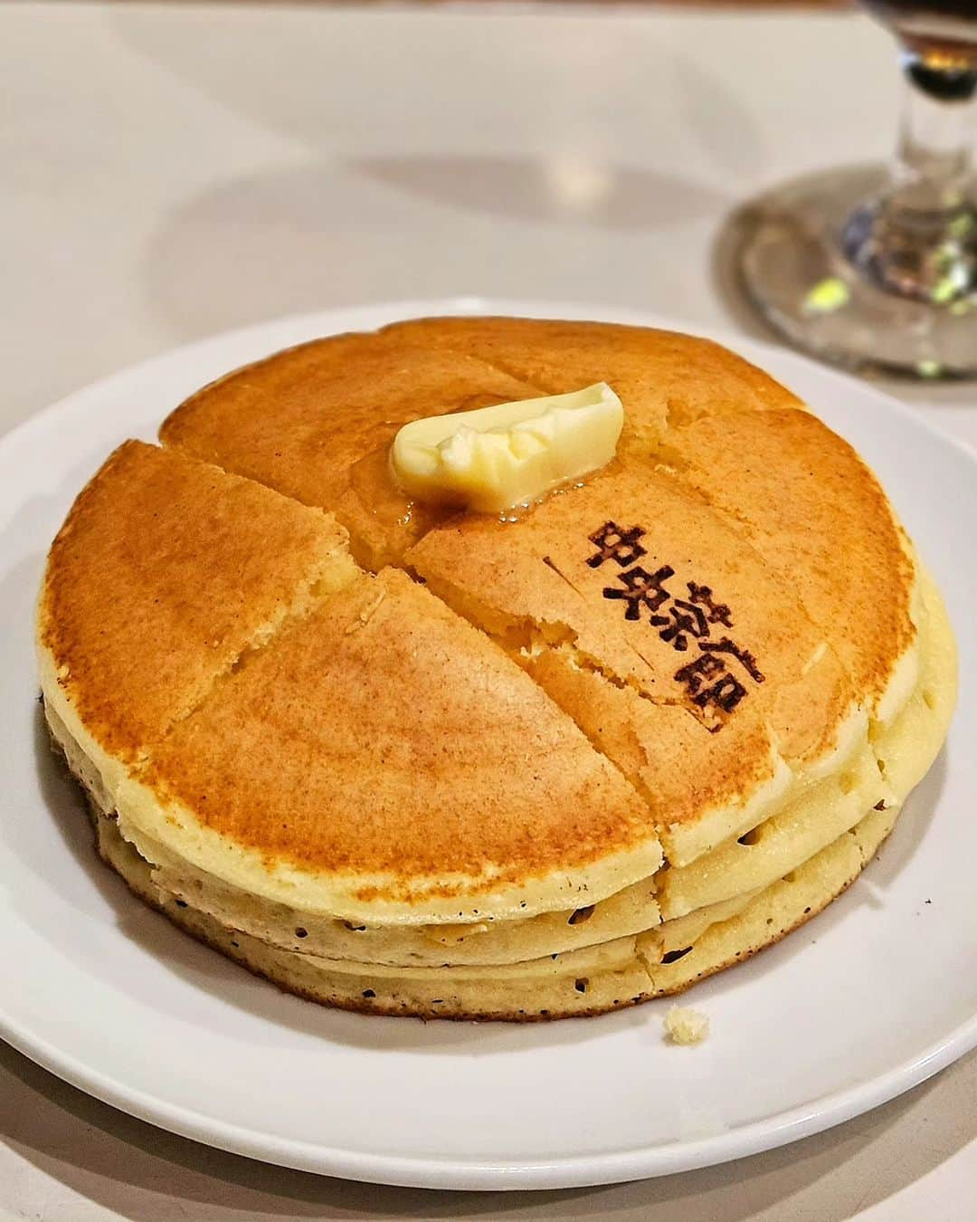 ミスター黒猫（黒猫仙人）のインスタグラム：「ホッとホッとホットケーキ♪ 【中央茶廊】 🥞ホットケーキ  石川県七尾市七尾駅にある 昭和28年(1953年)創業の自家焙煎珈琲の喫茶店 ずっと気になっていたホットケーキを目指して伺いました🚃💨  深緑の革製ソファー、BGMは昭和歌謡曲、現役のゲームテーブル ネオレトロではなく、昭和がそのまま残っている空間に癒されます  もちろんホットケーキは、注文を受けてから創業時から使っている銅板でじっくり焼き上げます 店名の焼印にテンションMAXひゃっほー！  外サクッと、中ふっくら生地に、メープルシロップが染み込み大満足の美味しさにゃー🐈‍⬛  ======================  🐾石川県七尾市府中町12 七尾駅から徒歩約10分  🍽グルメ・スイーツ情報は➡️ @mr_kuroneko  ======================  #黒猫食べ過ぎ #中央茶廊 #黒猫純喫茶 #君は放課後インソムニア」