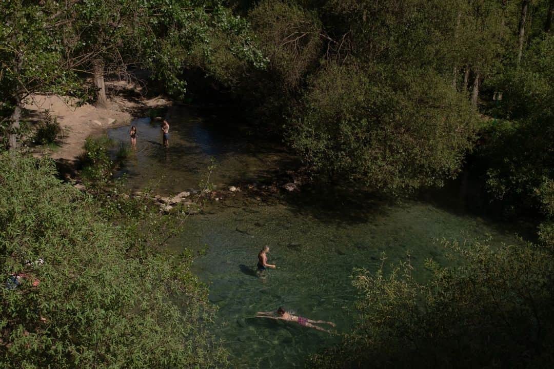 National Geographic Travelのインスタグラム：「Photo by @amritachandradas | The beautiful river located near Gato Cave in Montejaque, Spain. In the early summer my partner and I would visit the cave, where the temperature dipped a little lower, almost every day. Here, we saw families getting together for picnics, friends conversing, lovers having dates, and tourists entranced by the blue-green waters of the river. The waters were freezing, and I took sporadic dips on the days I was feeling brave.   Please follow me @amritachandradas for more insight into my work and travels.」