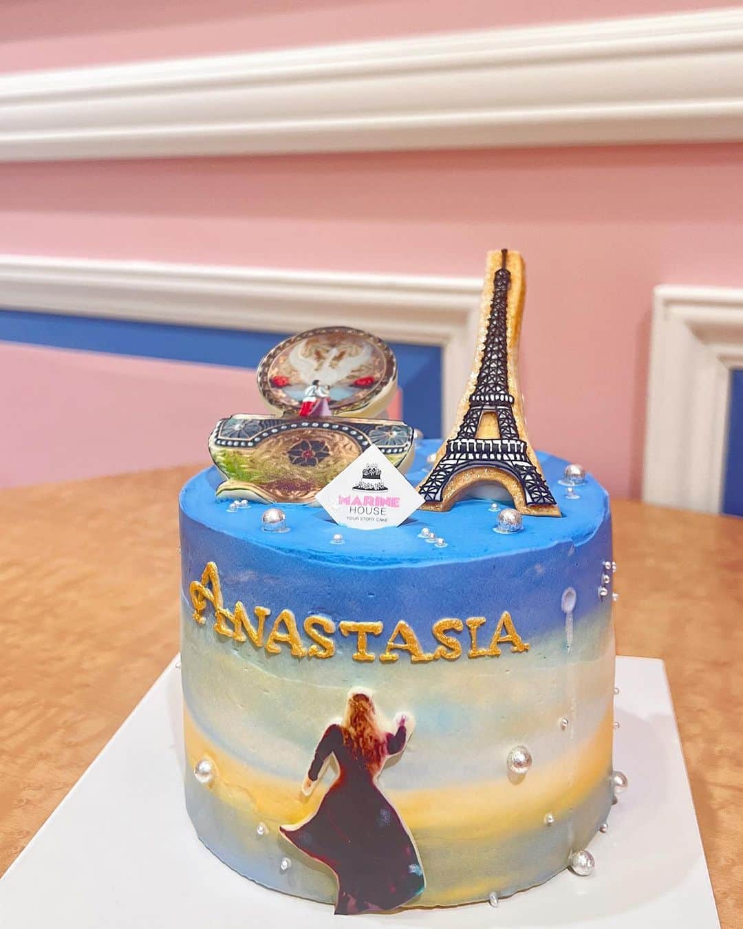 並川花連のインスタグラム：「@anastasiathemusical_japan🧁  アナスタシアケーキをオーダーしたくて 堀江にある  @marinehouse.horie_osaka  にてデザインして作って頂きました🩷🤍  かわいすぎる😍💓 そして凄すぎる再現度に感動🥹✨ オルゴールと、後ろ姿、アナスタシアの文字 エッフェル塔はほしいこと。 あとは雰囲気をお伝えしてお任せしたのですが 喜んでいただけたようでうれしかった🧁♡  中はショートケーキ🍰になってる〜！  息子の来年のバースデーケーキ🎂も ここでお願いしたいなぁ(気が早い)😅🤍  ありがとうございました♡ また宜しくお願い致します🤍  #PR #MARINEHOUSE」