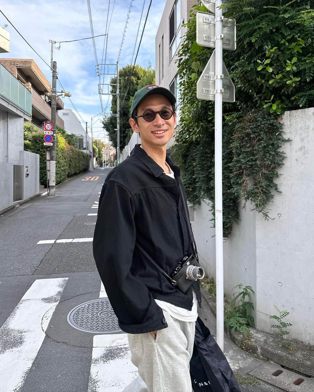 安井達郎のインスタグラム：「いや〜過ごしやすい気候だこと。 僕は天気に気分が左右される性分で、雨の日は妻曰く本当にテンションが低いらしい。まあ自分でも気づいているが。 逆に晴天だとご機嫌でとりわけTシャツに上着一枚で過ごせる今時期の20度前後だとパーフェクトなわけです。 そんな気持ちいい季節とお供している服たちは 上着  #comoli ズボン @brooksbrothersjapan  キャップ @llbeanjapan  カメラ #leicam9 買い物バッグ @deandeluca_jp @briefing_official」