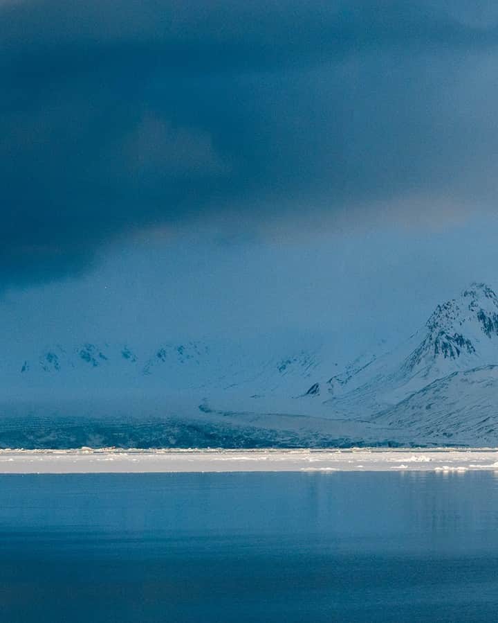National Geographic Travelさんのインスタグラム写真 - (National Geographic TravelInstagram)「Photo by @martinedstrom | Swipe to see the full panorama from Svalbard, Norway. Traveling through the Arctic beneath the midnight sun is a meditative experience. The sun never sets, so you sleep less and have golden light throughout the entire day. But the weather changes quickly, as seen here, when a thick, deep-blue storm rolled in from the west.   Follow @martinedstrom for more travel images from the Nordics.」10月22日 5時29分 - natgeotravel
