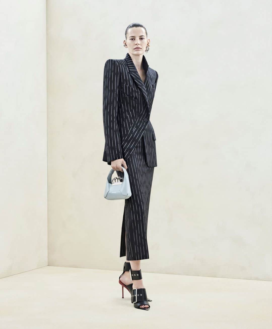 アレキサンダー・マックイーンのインスタグラム：「A black asymmetric tailored jacket and pencil skirt with a white broken pinstripe worn with the Mini #McQueenHoboBag and Punk Buckle sandals.⁣ ⁣ Discover #McQueenAW23 via the link in bio.⁣ ⁣ Photographed by @Jet.Swan⁣ Video by @EbbaHult⁣ Track: Neurons by @roblewiscomposer⁣ Music Director: John Gosling」