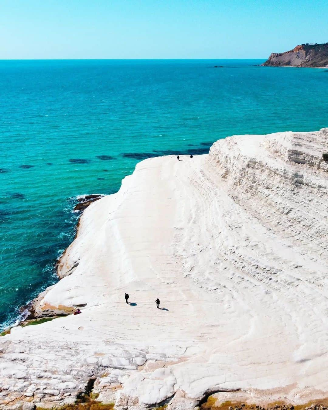 Coronaのインスタグラム：「Sicily has many natural wonders but one of its most striking is the Scala dei Turchi White Wall. ⁣ ⁣ ‘Scala’ translates to ‘stair’ which is fitting as the rocks have been shaped by wind and water erosion over thousands of years, giving them their smooth, stepped appearance.⁣ ⁣ Visitors can access this unique view via a beach entrance. Unsurprisingly, it is especially popular for those wanting to kickback and watch the sunset over the  crystal clear Mediterranean. ⁣ ⁣ #ThisIsLiving⁣ ⁣ 📸: @lucatriptico⁣ ⁣ #Italy」