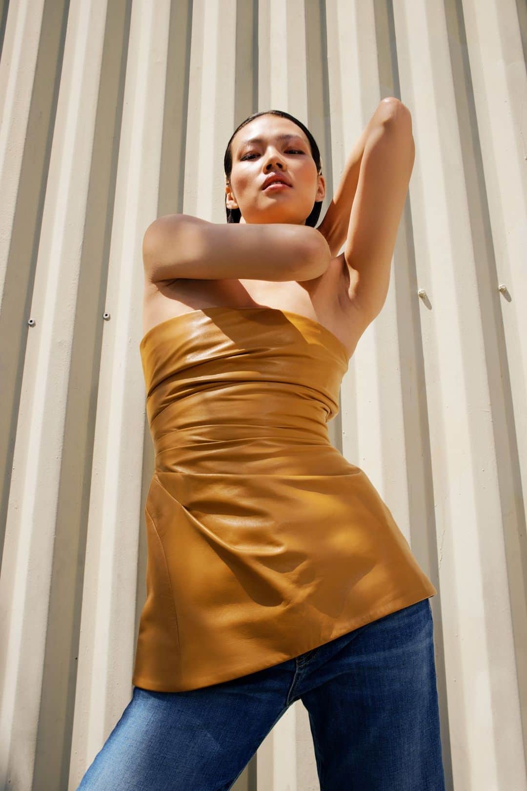barneysnyofficialのインスタグラム：「City vibes and caramel hues. Strutting sidewalks in the @proenzaschouler Glossy Leather Strapless Top. Effortless style, wherever you go. #BarneysAtSaks @saks」