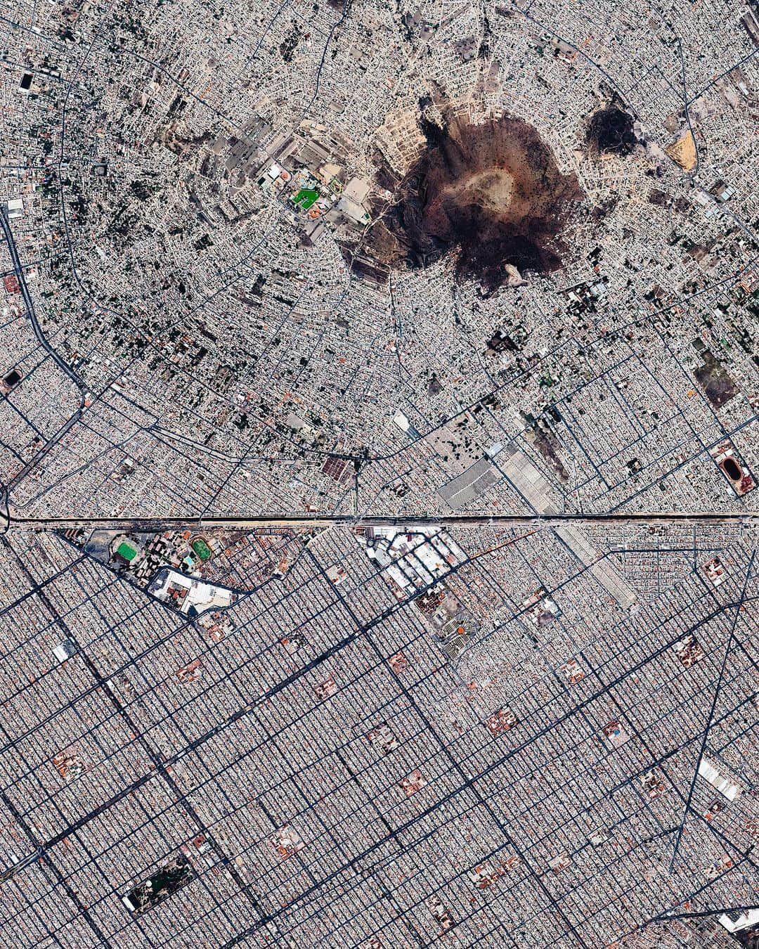 Daily Overviewのインスタグラム：「Chimalhuacán (top) and Ciudad Nezahualcóyotl are two municipalities in Greater Mexico City, with a combined population of nearly 1.8 million. Nezahualcóyotl is characterized by its long, straight, and gridded streets, while Chimalhuacán is arranged in a mostly radial pattern around the slopes of Cerro Chimalhuache. The two are separated by a canal of the Río de la Compañía.  Created by @dailyoverview Source Imagery: @maxartechnologies」