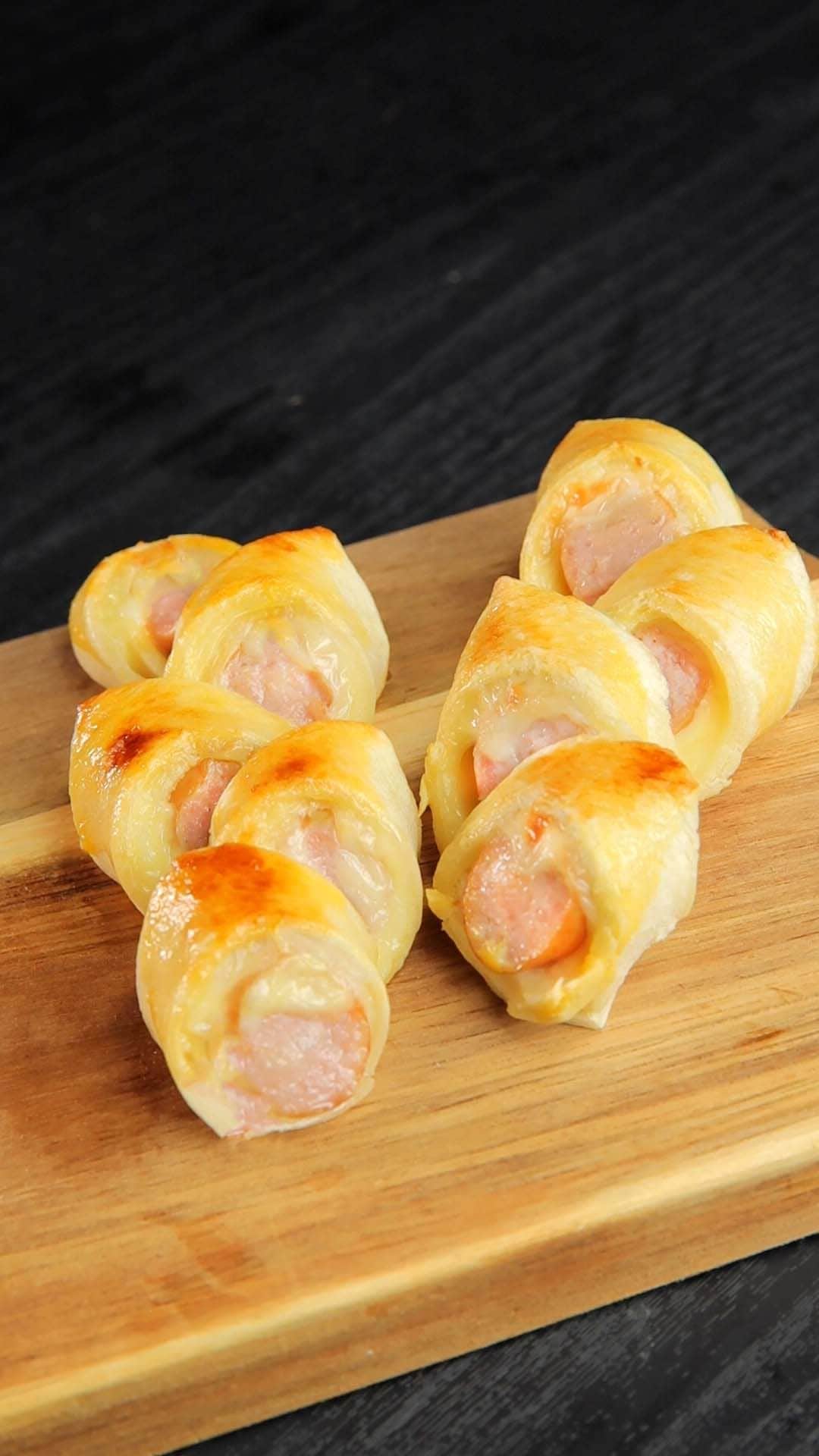 のインスタグラム：「@tastyjapan 👈他のレシピもチェック！ 【食パンが秒で食べ尽くせる旨さに！？】無限に手が止まらない  レシピが知りたい方はプロフィールのリンクをクリックしてね♪  ===  Easy Epi Bread with Sausage Servings: 2  INGREDIENTS 2 slices white bread 2 sausages 2 cheese slices Beaten eggs, as needed  PREPARATION 1. Cut crust off bread. With a rolling pin, roll out the bread. 2. Place the cheese and the sausage on the bread and roll.  3. With kitchen scissors, make cuts on (2). Brush the egg on it. 4. Bake in the toaster oven for 8 minutes. 5. Enjoy!  #tastyjapan #ソーセージエピ #エピ #食パンアレンジ」