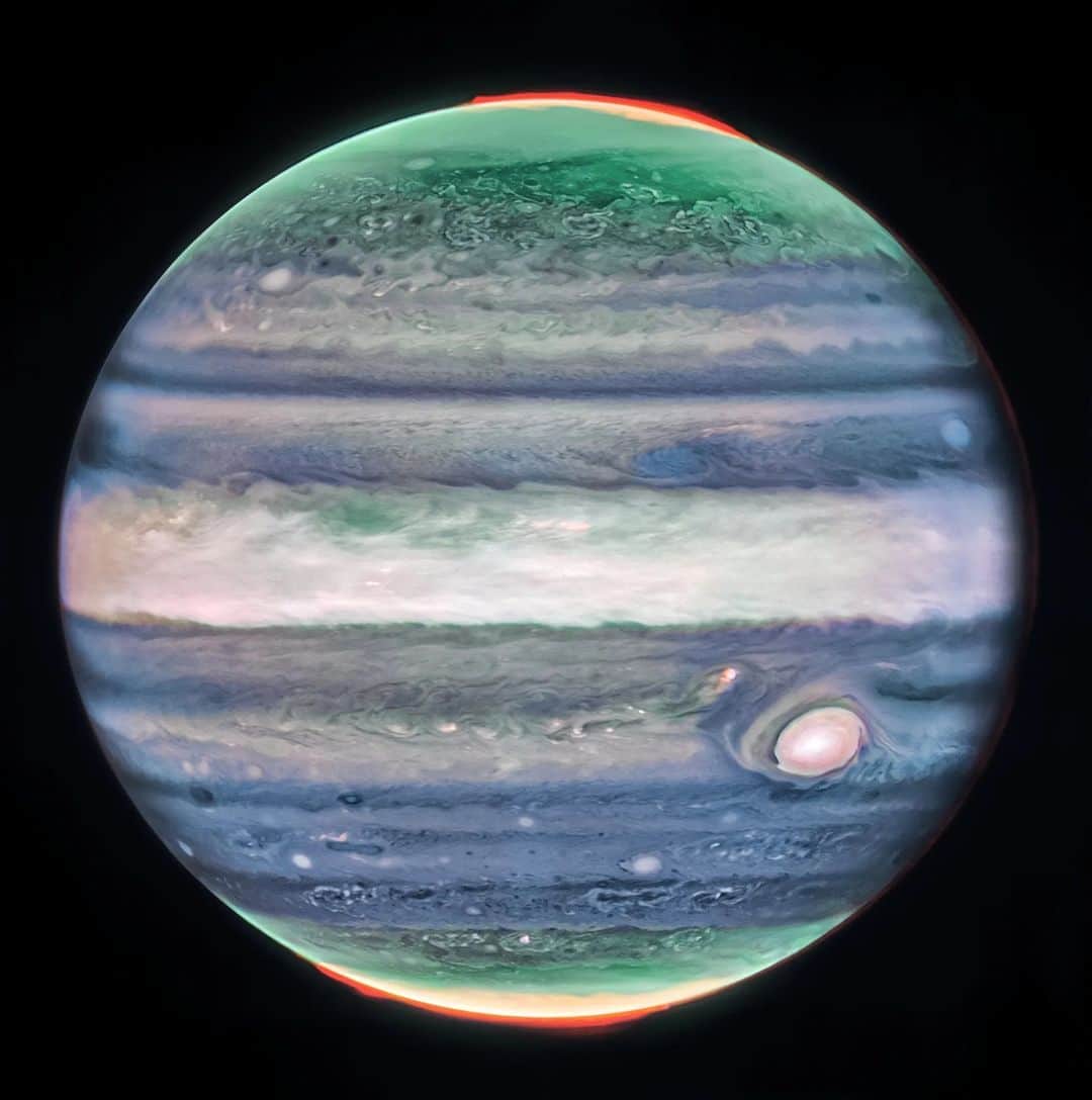 NASAさんのインスタグラム写真 - (NASAInstagram)「🎶 Now that Webb's looking at the atmosphere/With winds of Jupiter in its stare...  @NASAWebb spotted a never-before-seen jet stream in Jupiter's atmosphere, offering more insight into how layers of the planet's atmosphere interact with each other.  Image description: Jupiter dominates the black background of space. The image is a composite, and shows Jupiter in enhanced color, featuring the planet’s turbulent Great Red Spot, which appears white here. The planet is striated with swirling horizontal stripes of neon turquoise, periwinkle, light pink, and cream. The stripes interact and mix at their edges like cream in coffee. Along both of the poles, the planet glows in turquoise. Bright orange auroras glow just above the planet’s surface at both poles.」10月24日 3時06分 - nasagoddard
