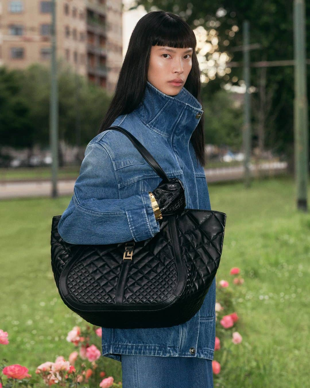 ジャンニヴェルサーチのインスタグラム：「Italian leather artistry and a structural design define the #VersaceGrecaGoddess tote bag.  Diane wears denim parka jacket; denim pencil skirt; Greca Goddess tote bag  Photography by Ilya Lipkin  #VersaceFW23 #Versace」