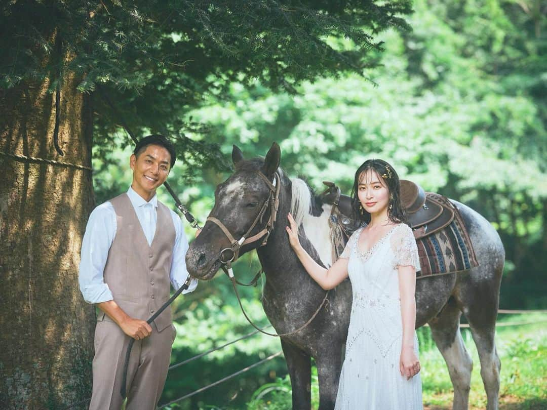 岩間恵のインスタグラム：「Scene 3. Farm.  これにて最後です！ ３着目も結婚式に着たジェニーパッカム @jennypackham のドレスで撮影でした♡  お馬🐴と心を通わせていた夫、さすがなのよ (特に２枚目の写真のお馬の表情...🥹)  自己満投稿にお付き合いいただきありがとうございました！コメントもたくさん嬉しいです🫶 Scene 1-3、どのスタイリングが好きですか？🥹🥰  Thank you @wd1110s @varie_dress  @kanesawamiho @tomoya_takano 🥳🥳  #ジェニーパッカム #jennypackham #インポートドレス #ウェディングフォト #ウェディングヘア #ウェディングアクセ」