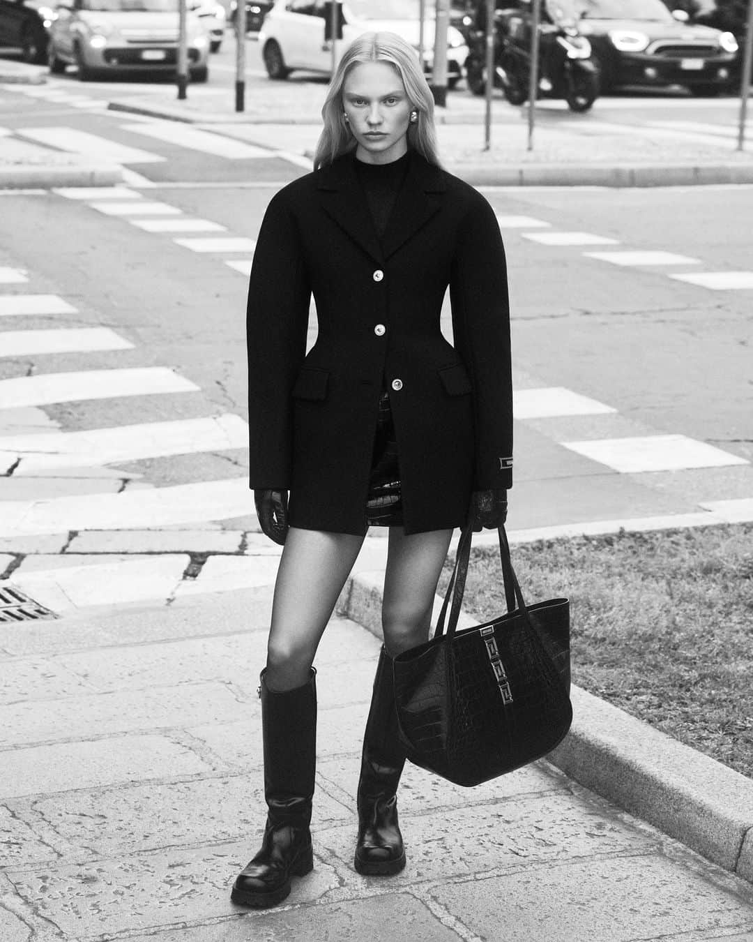 ジャンニヴェルサーチのインスタグラム：「Versace, Milan  Hourglass coat; mock-neck knit top; leather mini skirt; Alia boots; Greca Goddess tote bag  Photography by Ilya Lipkin  #VersaceFW23 #VersaceGrecaGoddess #Versace」