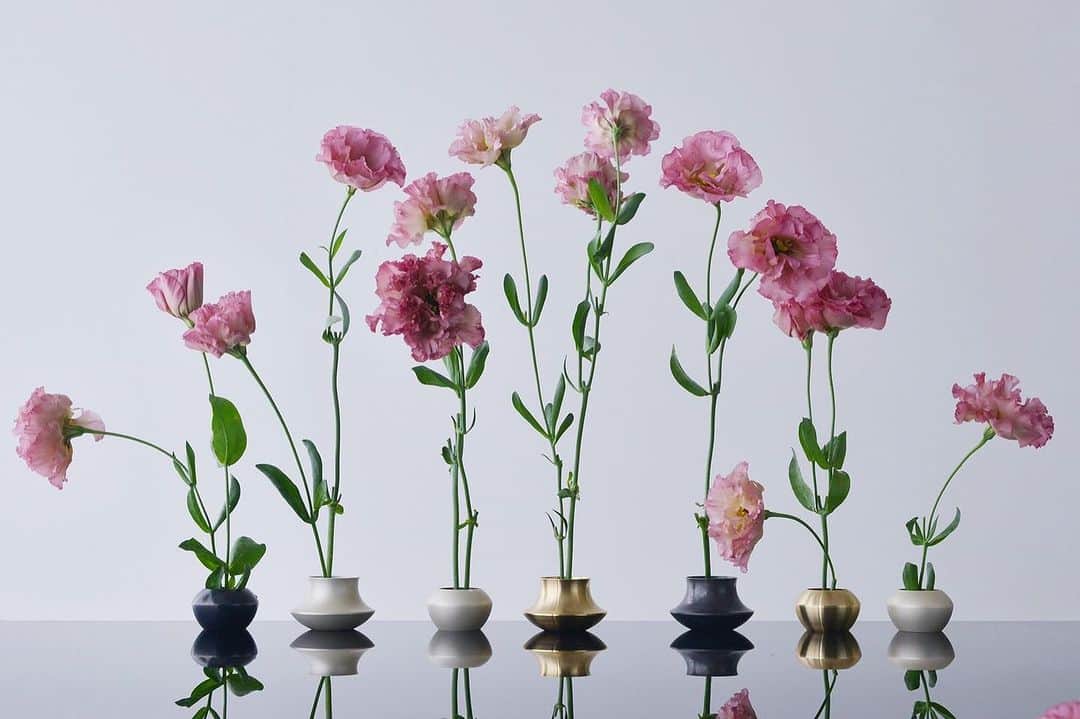 鈴木淳子のインスタグラム：「ちいさな花器を作りました。  私たちは物を大切にする、 永く愛でる日本文化をデザインを通して感じていただきたいと思っています。  1年前のまだ暑かった頃 商品を作ってみよう！ と主人に話したのがスタートライン。 さて、何を最初につくろうか…と クライアントワークをしながら のんびりと考えていました。  ガーデニング好きが高じて 小さな花でも、一本の草木でも、 最小のスペースでその植物の造形を愛でることのできる花瓶があったらいいのに... と プロダクトデザインが始まりました。  アーティストである主人の協力のもと 3Dモデリングをしていたのは、 軽井沢に滞在していた時。 私が好きな真鍮で出来ないだろうか、と 迷うことなく素材が決定し、 真鍮に特化しほぼ100%再生している 愛知県の工場と出会い 生産する事が出来ました。  KENZAN VASEは、 真鍮なので使うごとに風合いが増して行きます。 そして、永くながくお使い頂けます。  サイズは女性の手でも収まる2種 名前はGarlic🧄とMushroom🍄 にしました。  真鍮の色が美しいSolid Brass 純銀の淡い白のSatin Silver 柔らかな光沢の黒はOxidized Black  6種類の花器を28日(土)に発売予定です。  #KENZANVASE #DAKTEN #DAKTEN_collection」