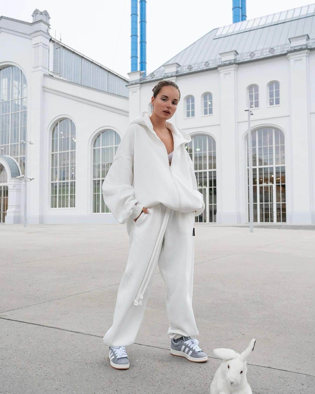 Sasha Spilbergのインスタグラム：「Живу в ритме большого города, но по своим правилам. Мегаполис обязывает: успевать, достигать, мечтать, стремиться. Я всегда за то, чтобы делать это строго в комфортных и уютных образах! 🤍🐇  На мне спортивный костюм мечты @macrocosm_store. В нём хочется жить! У ребят собственное производство в Екатеринбурге, и качество изделий круче, чем у многих западных брендов. Год прожив в Лос-Анджелесе, могу с уверенностью это утверждать! 🔥 Они создают идеальные, мягкие и теплые oversize модели: а специально для вас, промокод «spilberg» дарит -10% на заказ!   Еще я впервые побывала в ГЭС-2 и я в восторге от каждой детали интерьера и архитектуры этого места! На фото также спрятались белые кролики - это любимые мягкие игрушки моего детства. Они шикарно вписались в антураж.   Photo: @mamaspilberg」