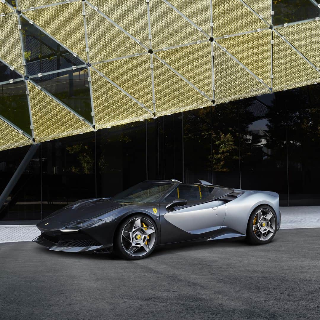 フェラーリのインスタグラム：「Welcome the ultimate addition to the #FerrariOneOff series: the Ferrari SP-8.  What truly sets this masterpiece apart is its open-top design, a roofless wonder that embraces the essence of a pure two-seater roadster, effortlessly showcasing its sporty character.  Its exclusive matte Argento Micalizzato colour pairs harmoniously with the carbon-fibre elements, which feature a unique glossy iridescent Blue Sandstone finish. Even the Blu Scuro Stellato colour that links the two bodywork sections was specifically developed for the model - elevating it to a league of its own.   #FerrariSP8 #Ferrari」