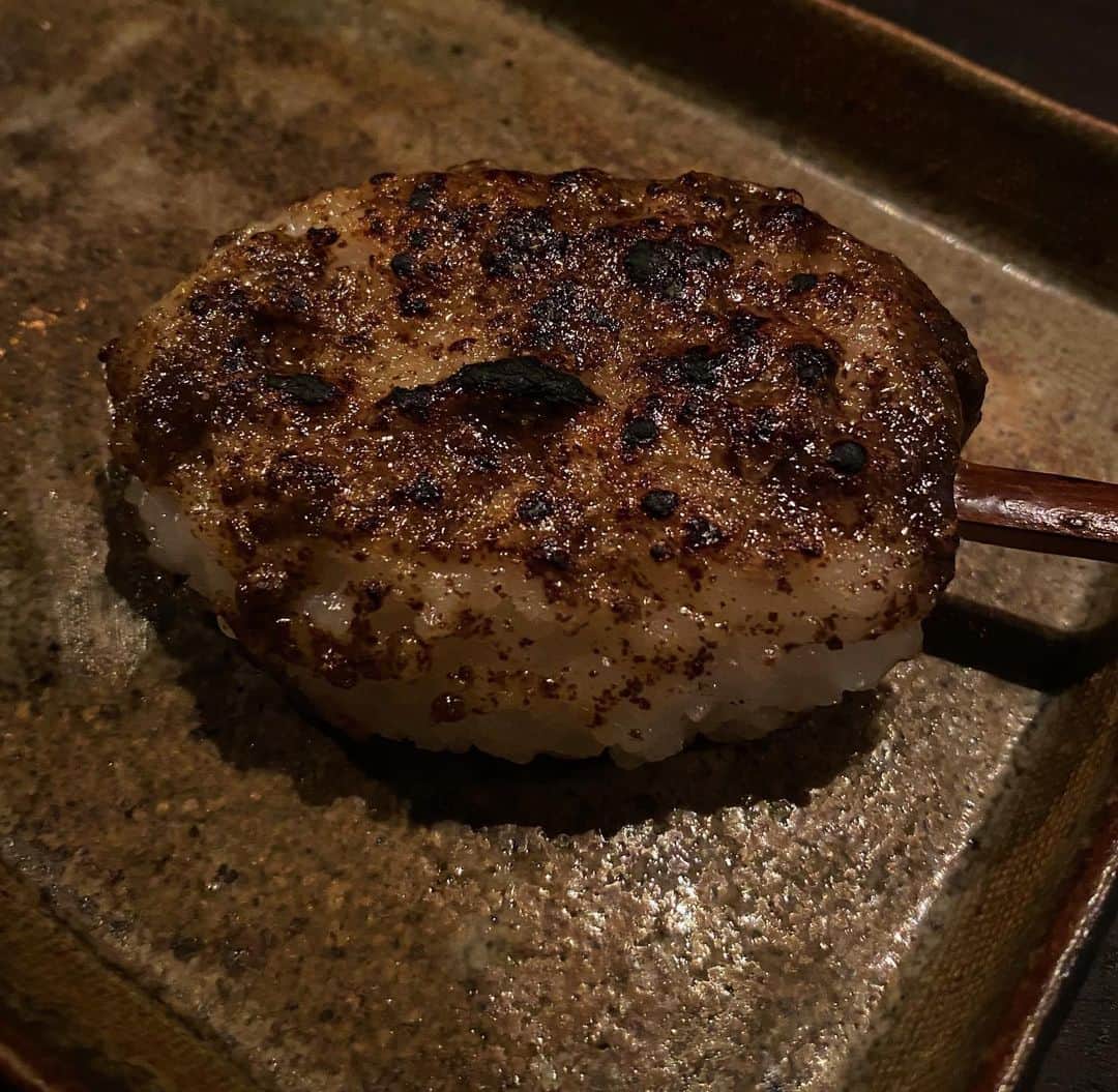 後藤しおりのインスタグラム：「今月の季節料理詰め合わせの献立にご用意している、田村黒種の荏胡麻を使用した懐かしい味の"じゅうねん味噌"。じゅうねんとは荏胡麻の種子のことで、生まれ故郷ではじゅうねんと呼んでいます。お野菜を茹でて和えものにしたり、郷土料理"しんごろう"にも使われます。  ごはんをすり潰し、卵型に丸め、じゅうねん味噌を塗って囲炉裏で焼く料理で、元々は新米の収穫祝いの料理でした。アトリエには囲炉裏がないので、焼きやすいよう平らにして作っていますが、寒くなってきたこの時期特に何度食べても止まらない美味しさ。栄養満点で土鍋底に残ったごはんも利用できるので、ぜひご家庭でお試し下さい。」