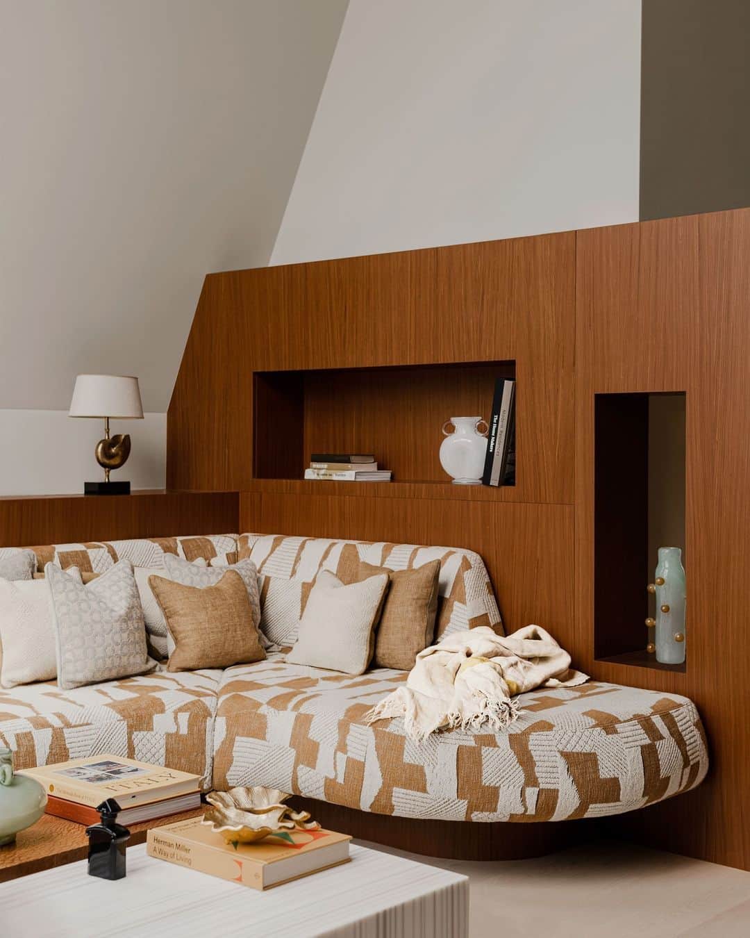ELLE DECORのインスタグラム：「Brutalism? Memphis? PoMo? This Polish home, designed by Zuza and Piotr Paradowski (@paradowskistudio), proves you don’t have to choose. Above all, the designers say, the biggest influences on their work are Polish postwar avant-garde artists like Władysław Strzemiński and Maria Jarema. “We are really in love with Poland,” Zuza says.  In one corner of the living room, custom millwork frames a bespoke sofa and tables.   Click the link in the bio to tour the rest of this arresting abode, as featured in our November 2023 Cities Issue. Written by @charlescurkin. Photographed by @pionfotografia.」