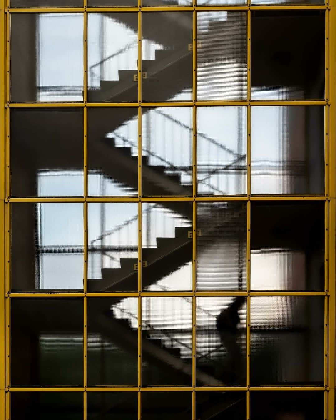 ライカのインスタグラム：「Composition  A balance between proportions, the art of noticing symmetry in photography.  The closer you look you'll see the stairs and window frames align perfectly and give that neat finish to the scene. Now if we turn our attention to the well-balanced stair walker, are they walking up or down?  📷: @liu_mingzu_ with Leica M10R  #LeicaCamera #Leica #🔴📷」