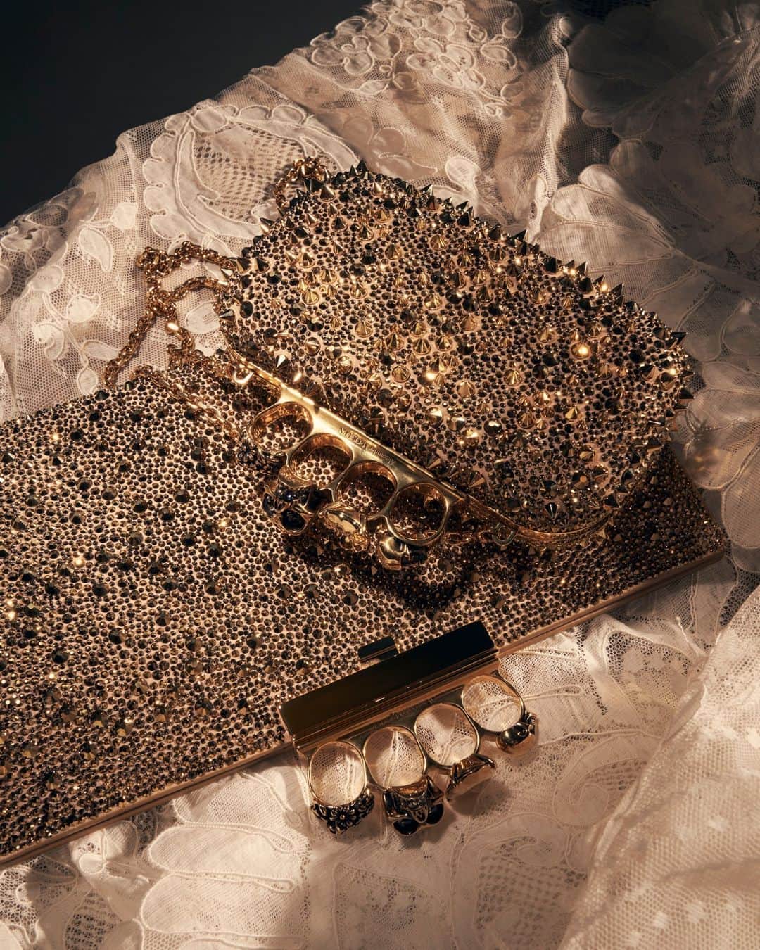 アレキサンダー・マックイーンのインスタグラム：「Re-imagined for the holiday season.⁣ ⁣ The #McQueenKnuckle Flat Pouch and Clutch with gold crystal embellishments.⁣ ⁣ Discover #McQueenGifts via the link in bio.⁣ ⁣ Photographed by @maximepoiblanc」