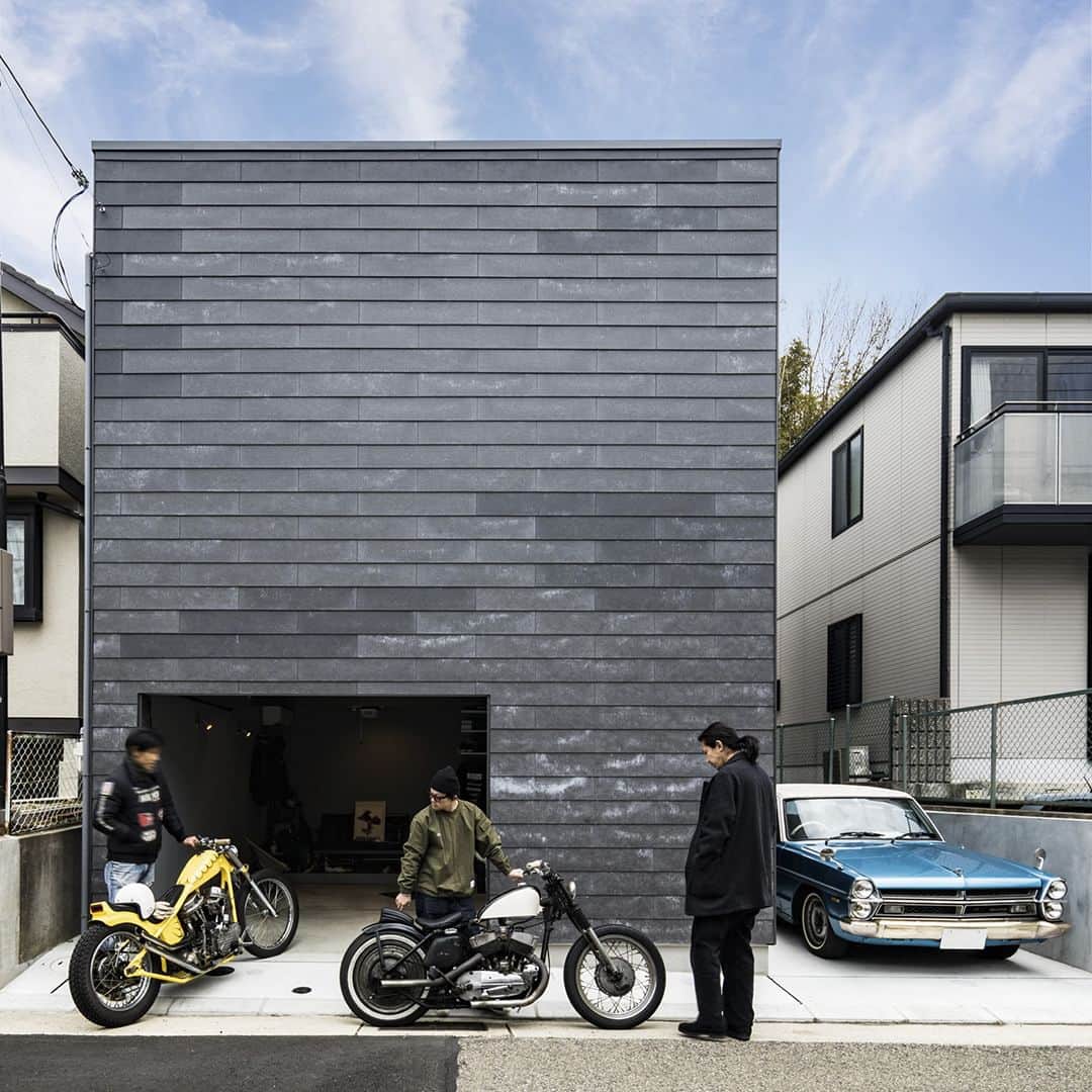 ザウス住宅プロデュースさんのインスタグラム写真 - (ザウス住宅プロデュースInstagram)「神戸市垂水区に位置する、奥に高低差が1m以上ある敷地に建つガレージハウス。ガレージ内の道路とフラットエリアをビルトインガレージと駐車スペース（外置き）として活用。ビルトインで3台以上のバイクを収納できます。さらにガレージの奥にはフローリングが施され、椅子やテーブルが配置され、友人たちとバイクについて語り合うスペースとしても活用。ガレージドアは金属製のオーバースライダーを採用。ガレージ内でバイクのメンテナンスも心置きなく行えるように床と壁に水に強い外壁材を採用。  この住宅は敷地の高低差を活かし、一見木造2階建てに見えるものの、スキップフロアを採用することで建物奥が3層になっており、費用を抑えつつ、視線に上下の動きを生み出し、空間に変化をもたらしている。1階にはガレージのほか、寝室と広いウォークインクローゼットが配置されており、玄関もガレージに直結しています。  #garagehouse #garage #bikes #ガレージハウス #ガレージ #kobe #垂水 #kmew #solido #スキップフロア #ガレージのある家 #garagelife」10月25日 13時51分 - zaus_producer