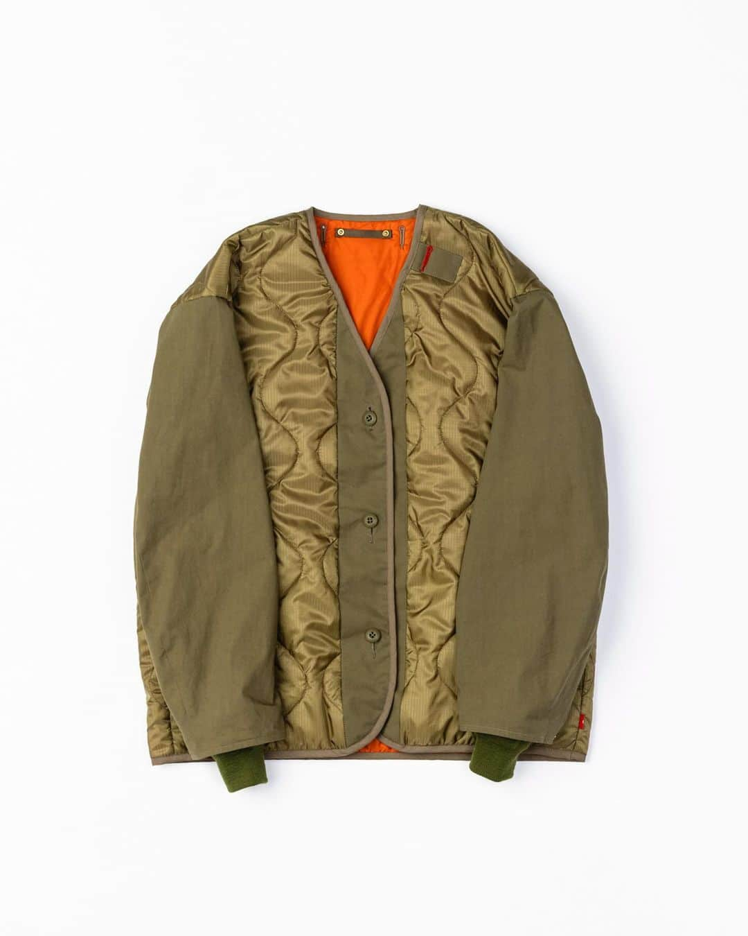 アナクロノームのインスタグラム：「. AN265 REVERSIBLE QUILTED JACKET OLIVE  [アイテム : リバーシブルキルティングジャケット] [Item : Reversible quilted jacket]  ■高密度ナイロンリップストップのオリジナルキルティング生地と、ハリのある高密度コットン生地との切り替えが特徴のM-51ライナータイプジャケット。  フロントに太鼓ボタンを採用することで、ボタンを付け替えてリバーシブルで着用することが可能です。  ■表地：(見頃)オリジナルナイロンダブルリップストップキルティング 60gの程よい中綿入りのオリジナルキルティング。 30Ｄのブライト糸を採用し、60年代のアメリカ軍ナイロンＷリップを再現しています。 非常にライトなウェイトで、柔らかい肌触りと光沢が特徴。  裏地 : ナイロン高密度タフタ 50デニールの太さの糸を高密度で織り上げたナイロン織物。 程よいハリ感とナイロン独特の優しい風合いを兼ね備えています。  袖 : コットン/コーデュラオックスフォード コットン/コーデュラの混紡糸を使用し高密度に織り上げたオックスフォード生地で、水が染み込みにくい素材となっております。  コーデュラナイロンを使用することで、タフさと摩耗への耐性が向上。  ※リブにウールを使用しているため、乾燥機のご使用はお控えください。  ■素材 : 身頃 : NYLON 100% / 裏地 : NYLON 100%  / 袖部 : COTTON 70％ NYLON 30％ / リブ : WOOL 100%   ■原産国：日本 ■Country of Manufacture：JAPAN   海外発送も可能です。 Overseas dispatch is also possible.   MODEL 身長：173cm 体重：62kg 着用：SIZE 02」