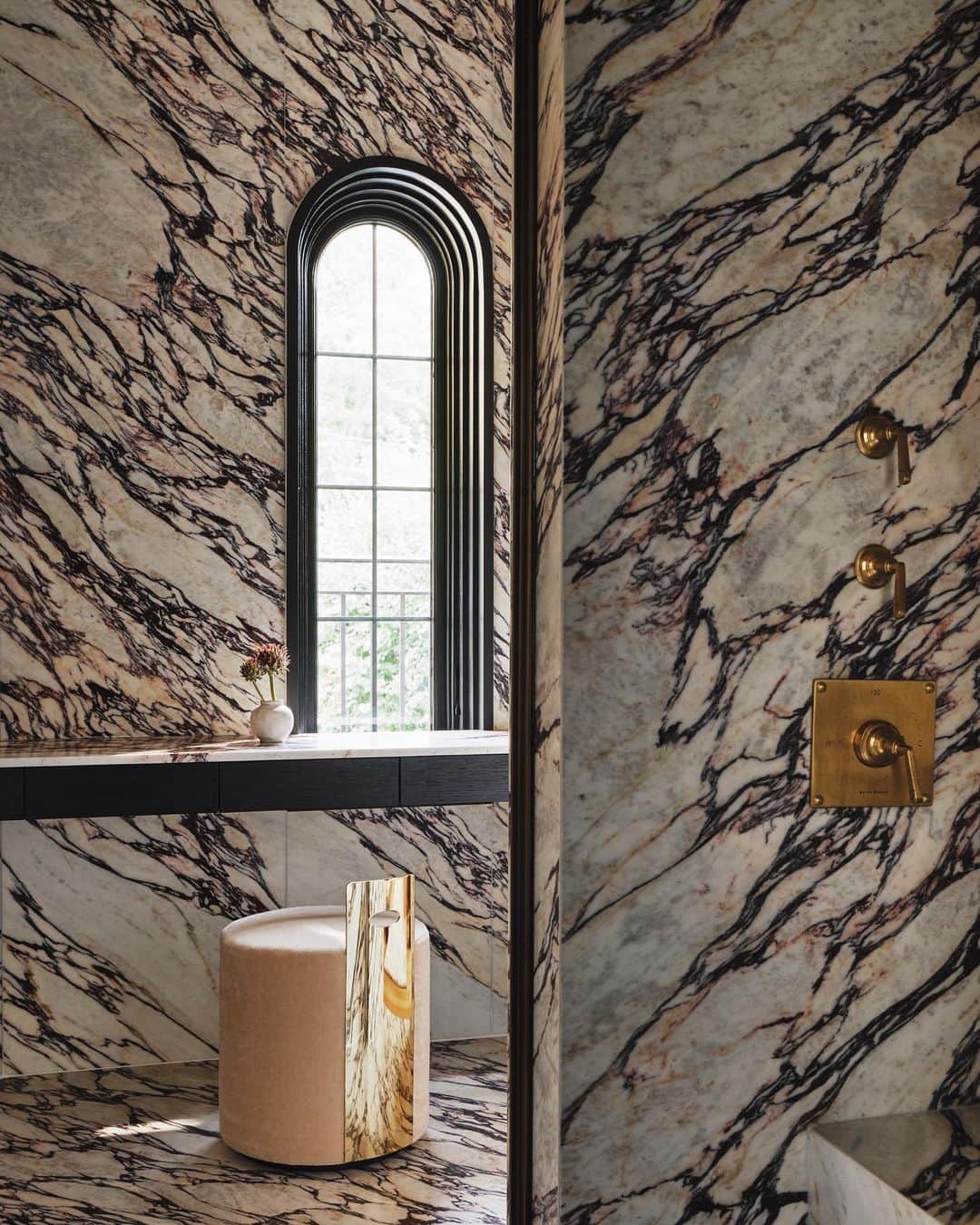 ケリーウェアスラーのインスタグラム：「MULTI-LEVEL BATH Soaking up weekend vibes in this multi-level bathroom clad in Viola Antica marble. In this historic property, my studio and I modernized and transformed this primary suite bathroom. The highlight is a unique double-sided shower, seamlessly integrated into the multi-tiered space. Complementing this is a well-appointed his and her closet with a barrel vault ceiling. Every thoughtful detail we designed adds the perfect touch for weekend beauty and wellness rituals. XK」