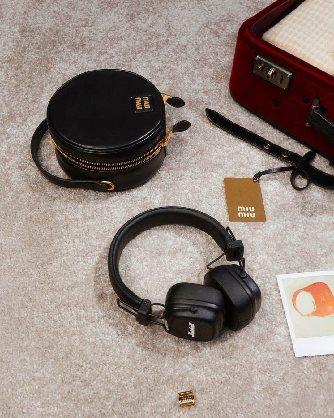 のインスタグラム：「@MiuMiu has come together with @MarshallHeadphones, designing neat, rounded black leather cases with polished gold branding in a special co-branded box.   Photographed by @Annemarie.Kuus.  Creative direction by @EdwardQuarmby.   #MiuMiuHoliday」