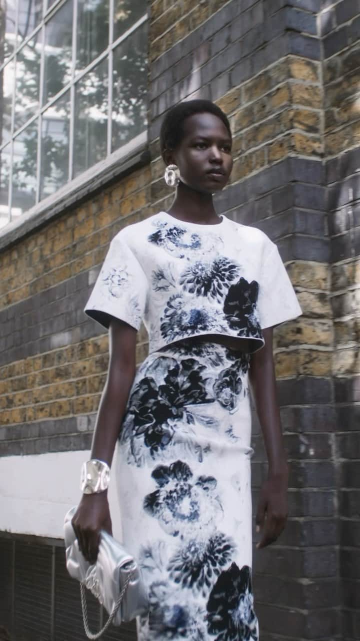 アレキサンダー・マックイーンのインスタグラム：「Flower embroideries in chiaroscuro appear across a top and pencil skirt, worn with the #McQueenSeal bag and #McQueenPunk mules in silver.   Discover the collection via the link in bio.  Video by @EbbaHult⁣⁣ Music Director - John Gosling ⁣ Track - Leipzig by Toby Andersen」
