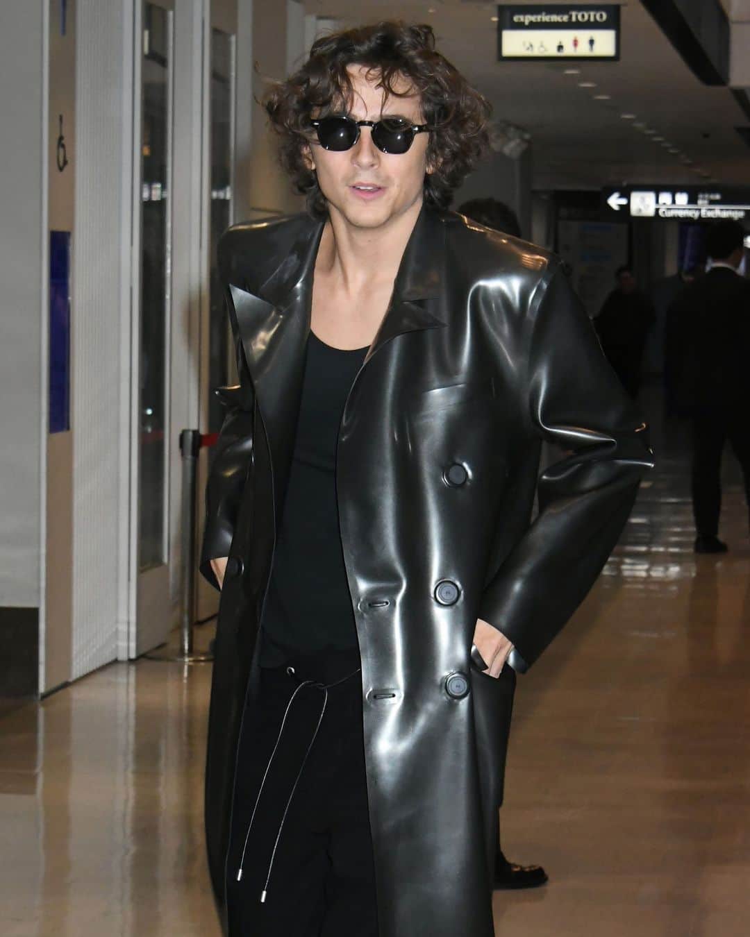 Vogueのインスタグラム：「Last night, while arriving at the Narita airport in Japan, actor Timothée Chalamet (@tchalamet) rejected any preconceived notions about what one should wear to the airport. Instead of conventional comforts, he opted for a sleek look that was more catwalk-ready than plane cabin-ready, wearing a black latex jacket that looks like it came straight out of 'The Matrix.' Tap the link in our bio for all the details on his airport look.」